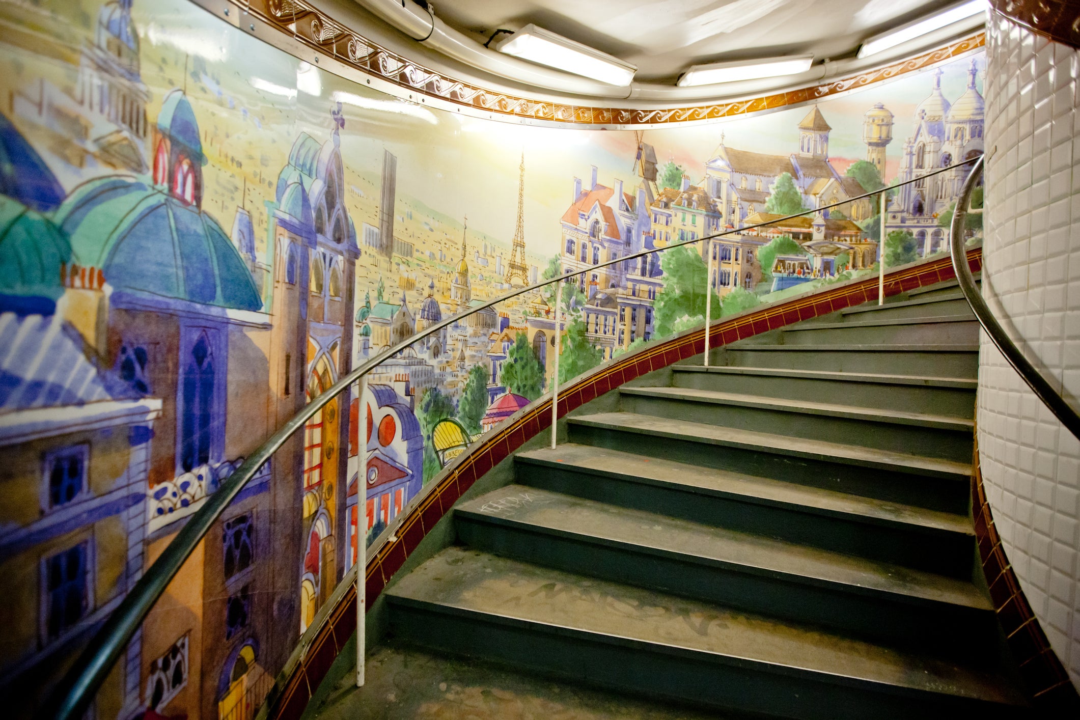 The 176 stairs of Abesses station are lined with photos and murals like an art exhibition