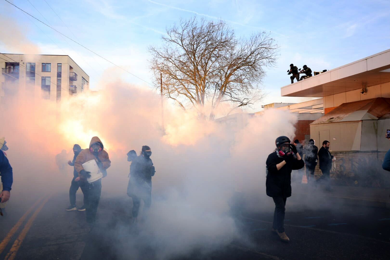 Federal agents lob tear gas and flash bangs at protesters in front of the ICE building on Jan. 31, 2026, in Portland, Oregon. The lawsuit comes after another weekend of mayhem outside the facility, where federal agents launched tear gas at a crowd of demonstrators — including young children