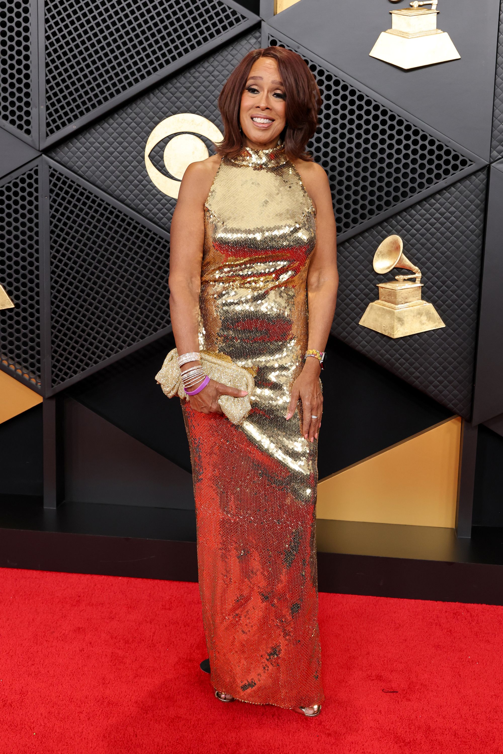 Gayle King was a vision in gold in a luminescent gown with a halter neckline