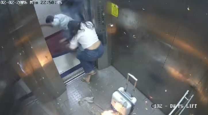 Screengrab from CCTV footage shows two people rushing out of an elevator after gas-filled balloons catch fire