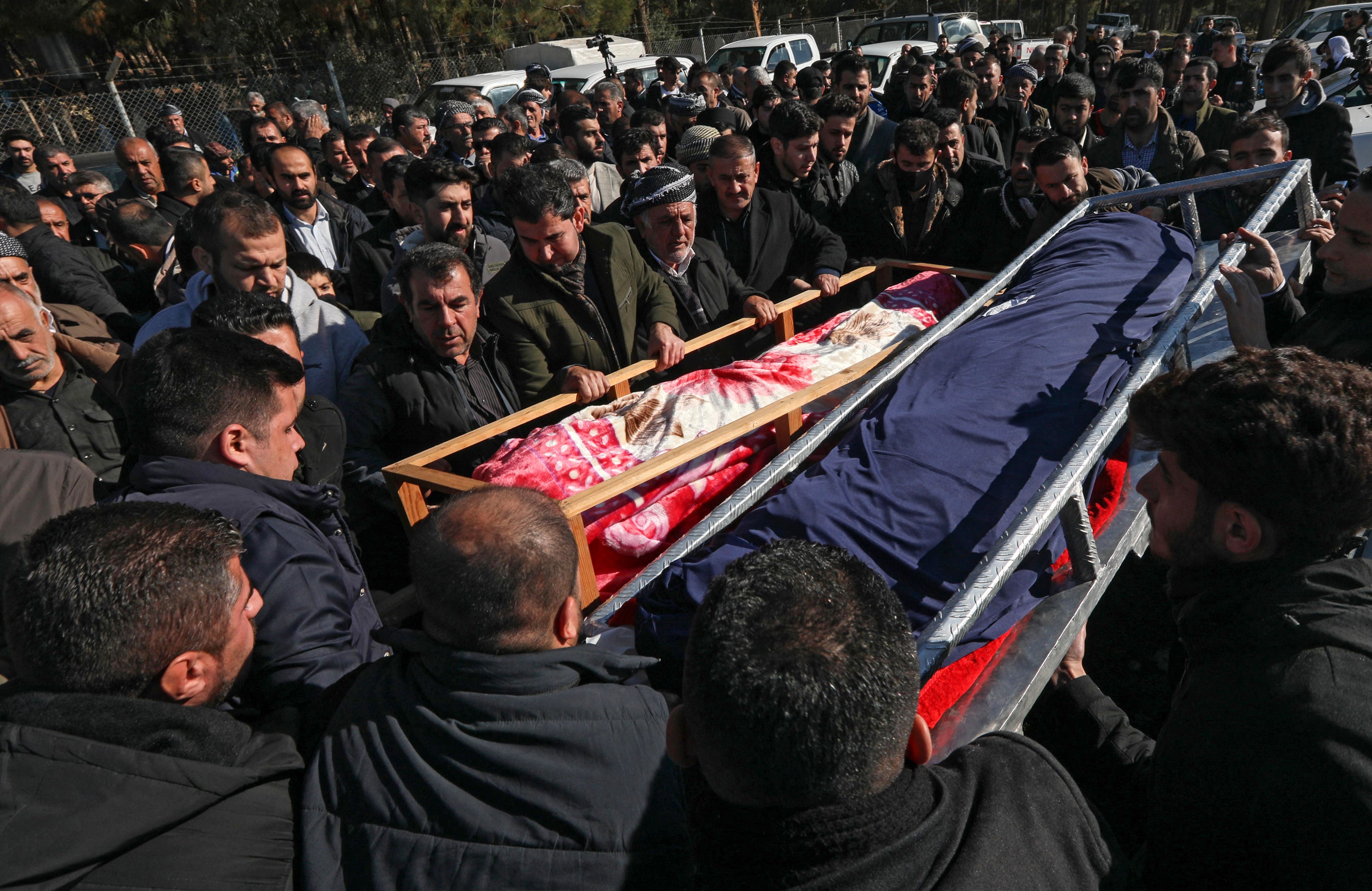 Relatives of the 16 Kurds, killed when their boat sank in the Channel while trying to reach England, carry the body of two of the 16 during their funeral in Raniya, east of Arbil, the capital of Iraq's northern autonomous Kurdish region late on December 26, 2021. At least 27 people perished in the November 24 tragedy, the deadliest disaster since the Channel became a hub for clandestine migrant crossings from France to England.