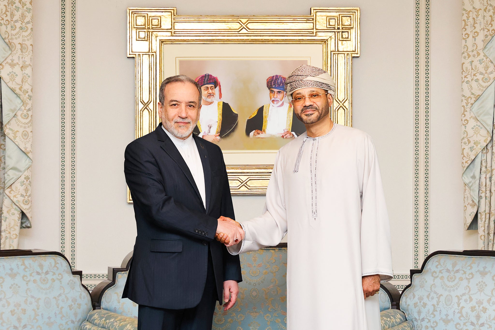 A photo released by the Omani Ministry of Foreign Affairs on February 6, 2026, shows Iranian Foreign Minister Abbas Araghchi (L) shaking hands with Oman's Foreign Minister Badr bin Hamad al-Busaidi in Muscat