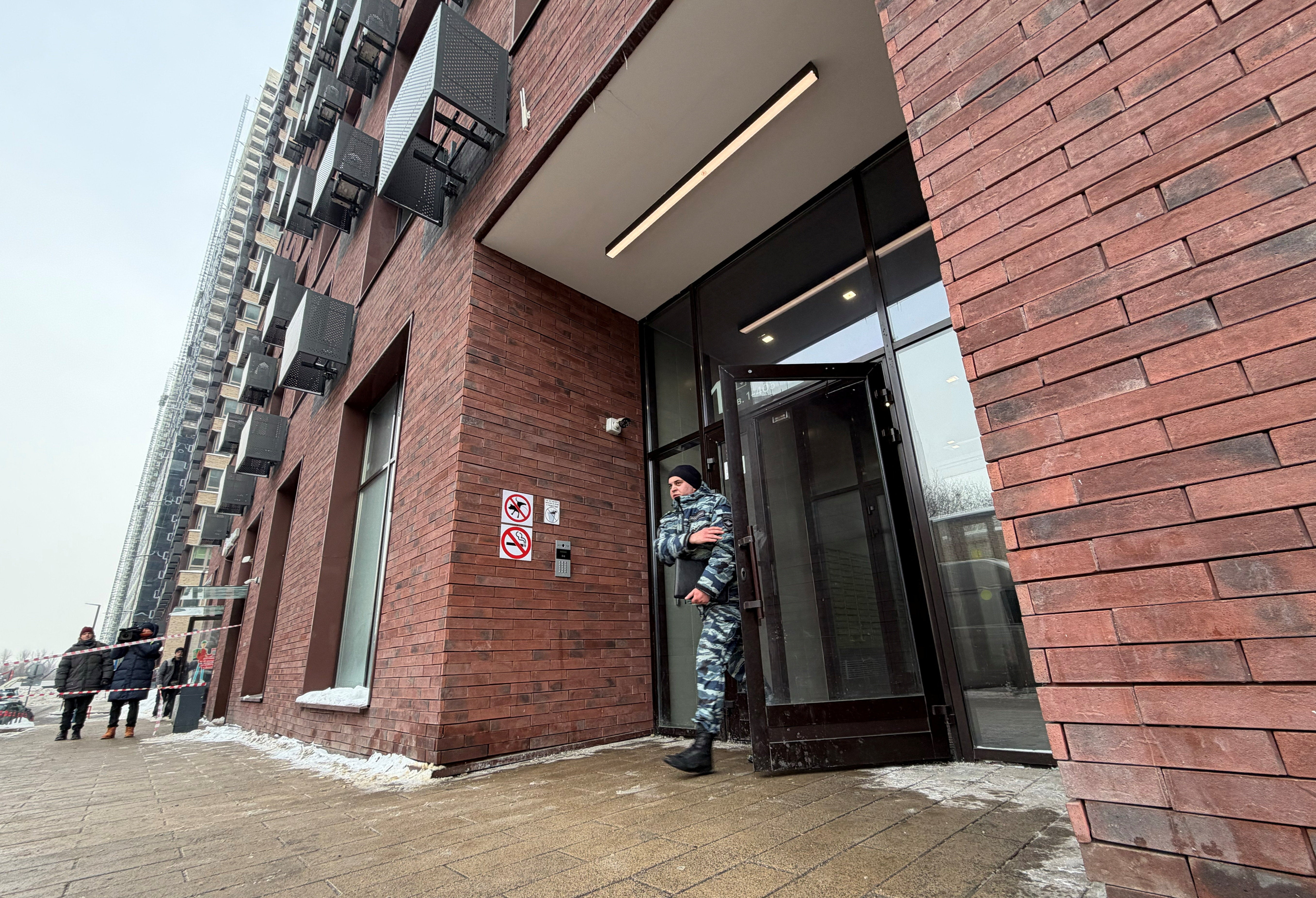 A police officer comes out of a residential building where the assassination attempt on Lieutenant General Vladimir Alexeyev took place