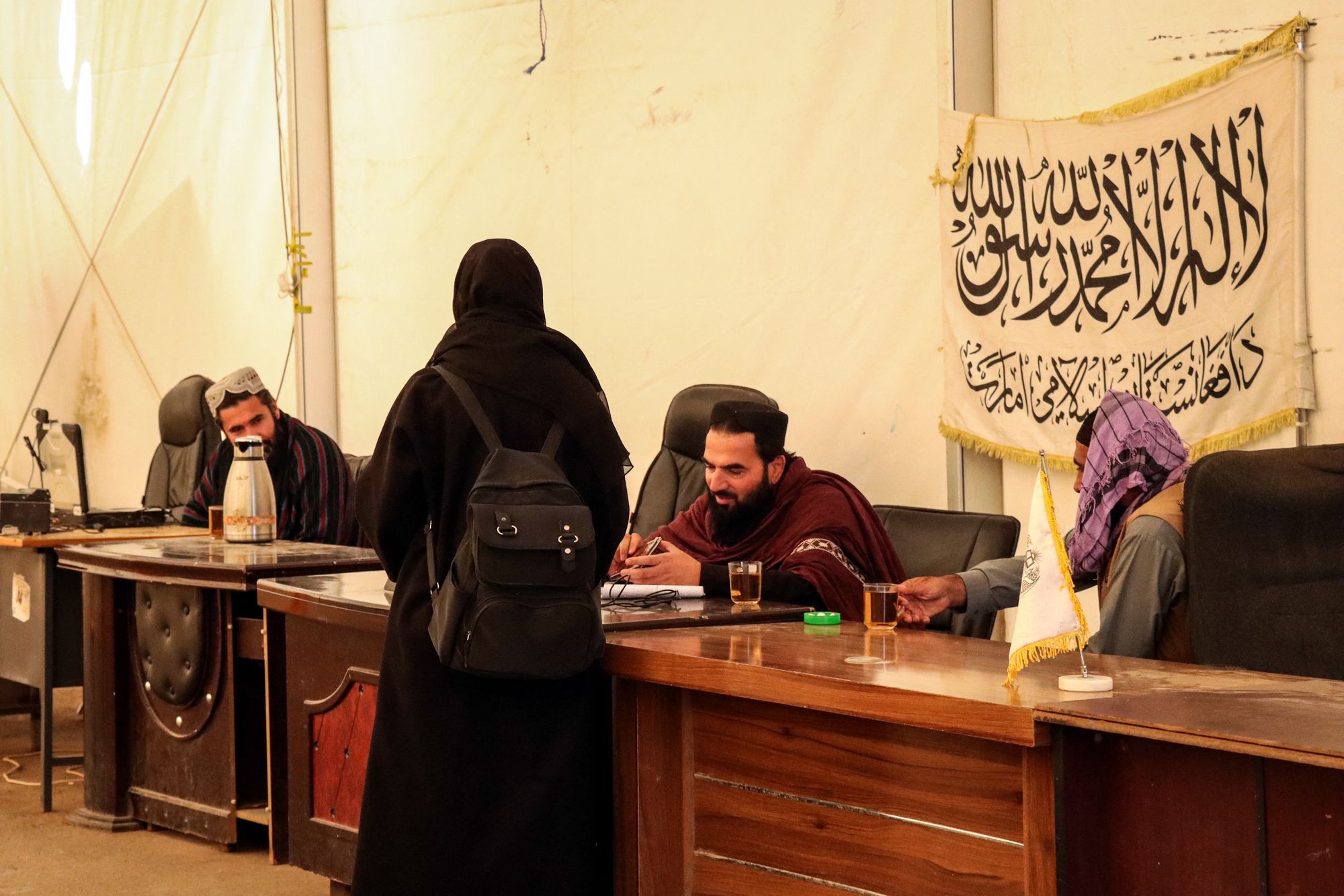 Taliban workers from the Department of Immigration Affairs register an Afghan woman returnee from Iran in Herat
