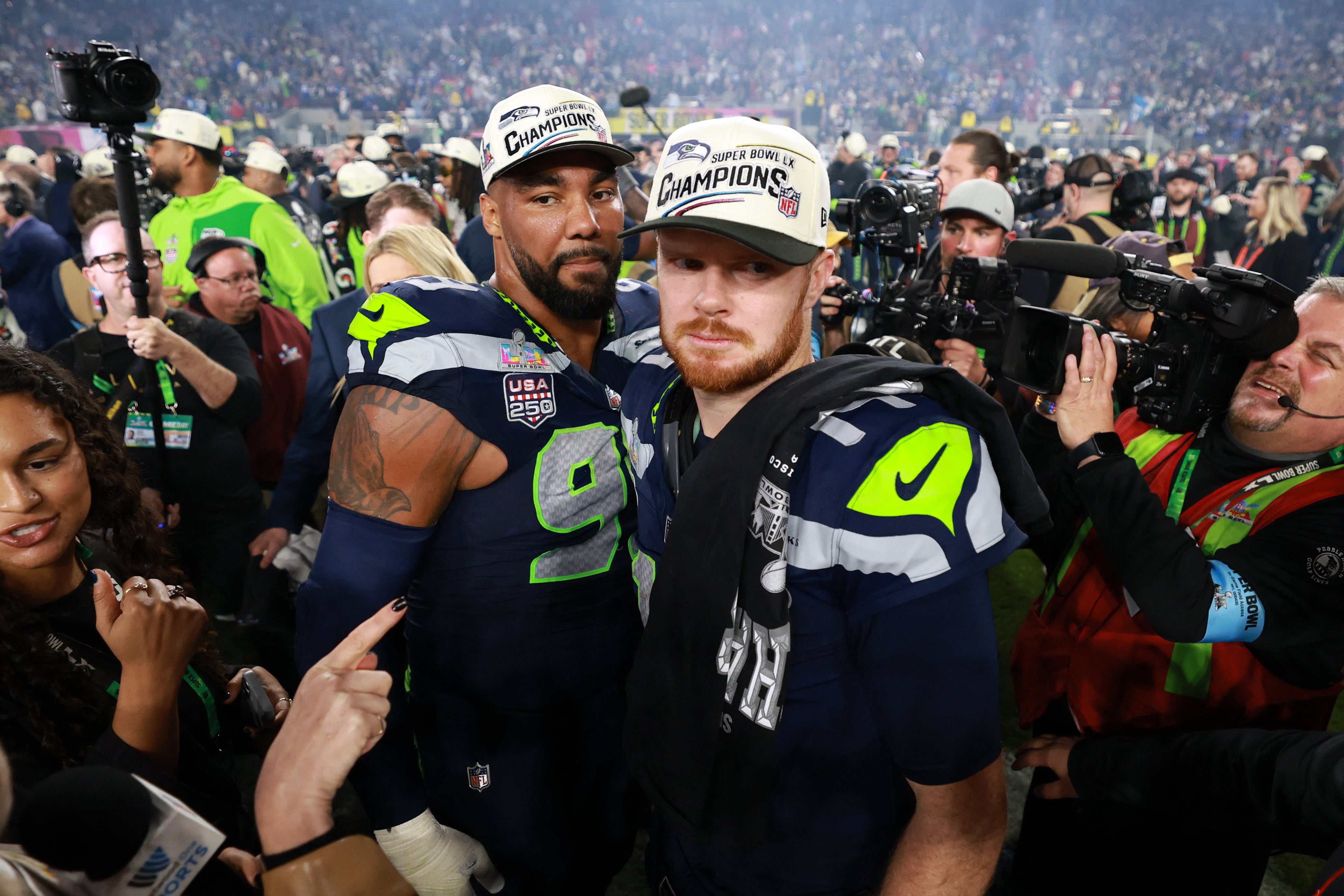 Seattle Seahawks quarterback Sam Darnold (14) and defensive end Leonard Williams (99) react after defeating the New England Patriots in Super Bowl LX