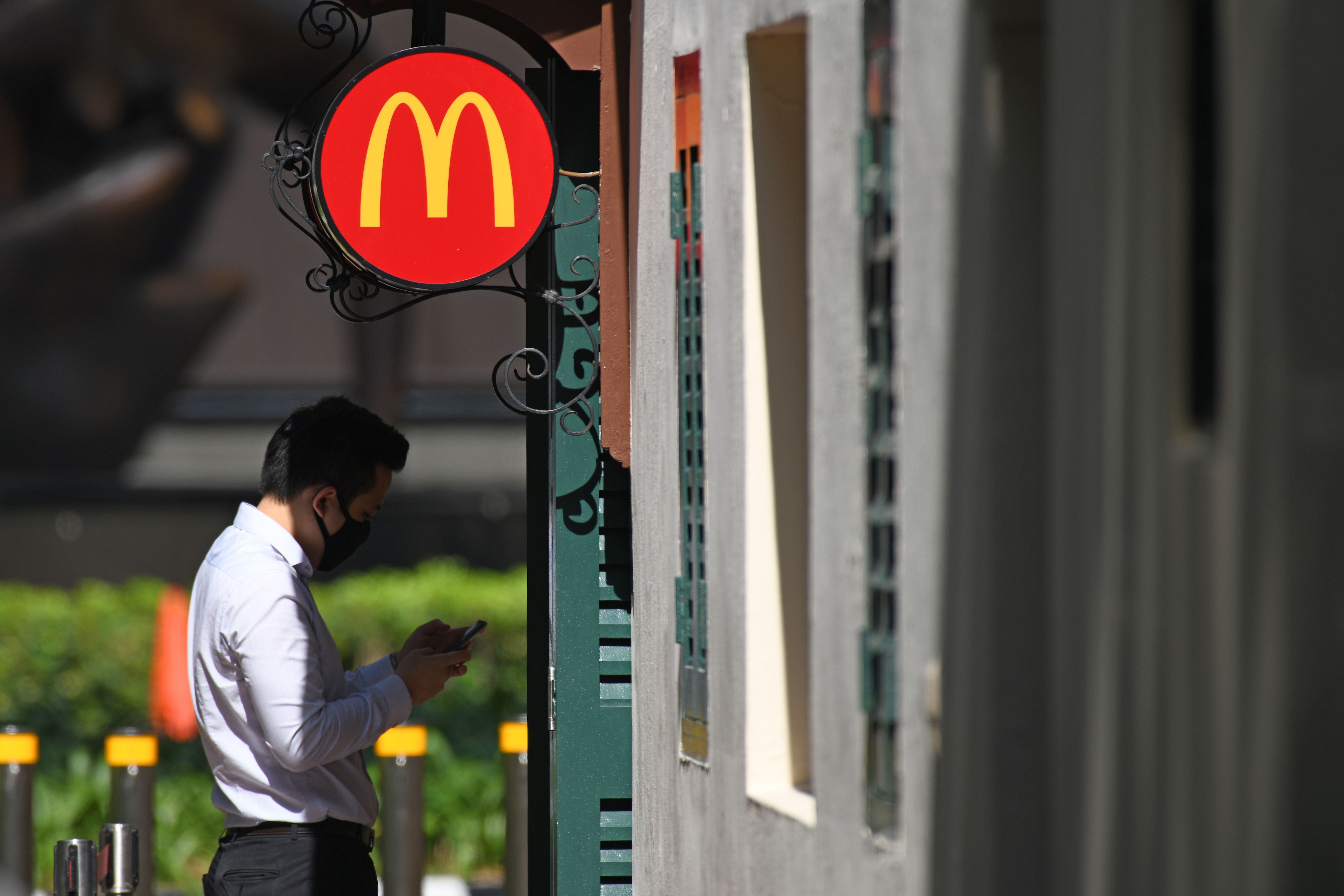 <p>File. Representative. A man waits outside a McDonald’s fast food restaurant in Singapore</p>
