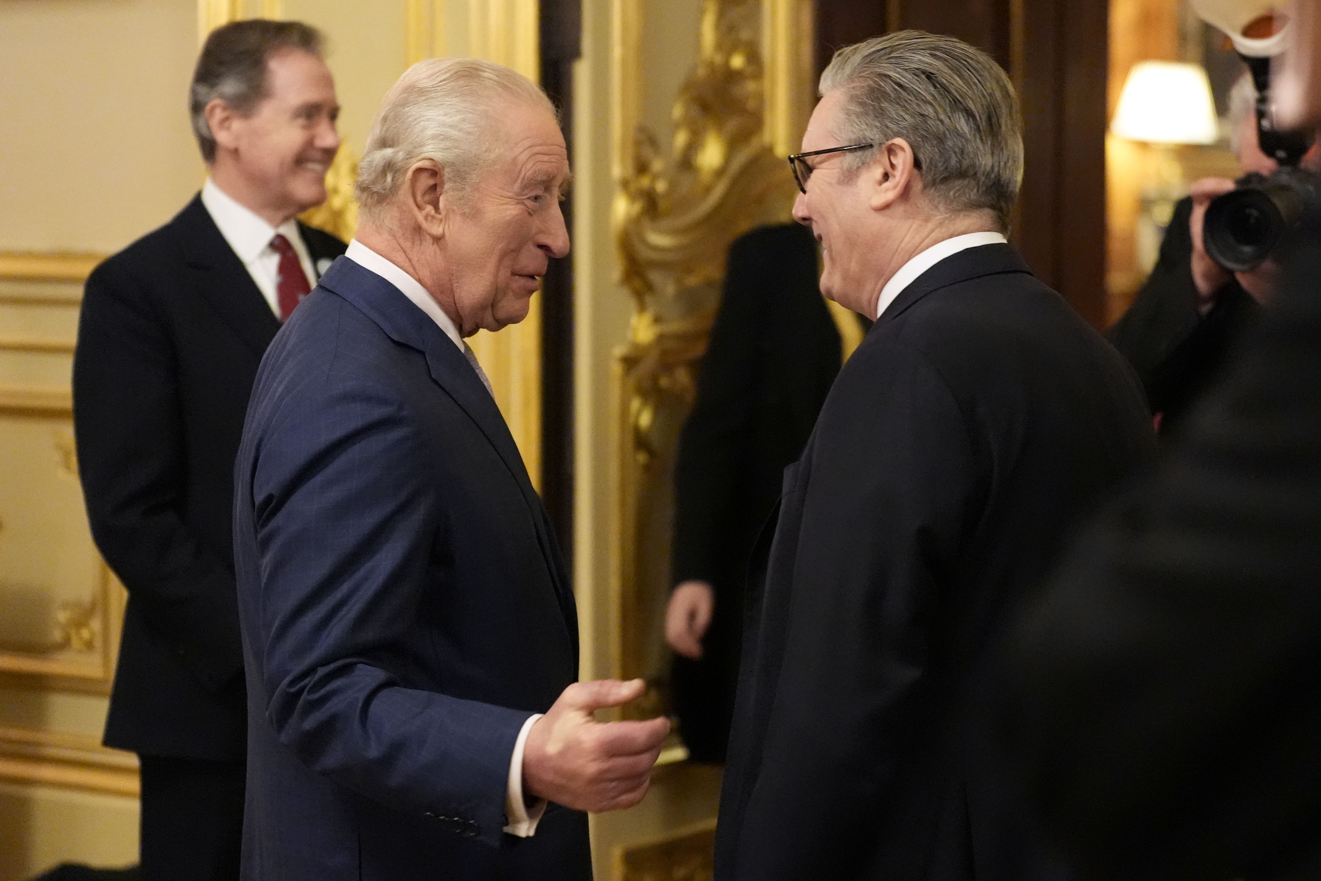 Charles speaks to Sir Keir Starmer during a reception to highlight the inspirational work of paid and unpaid carers at Windsor Castle (PA)
