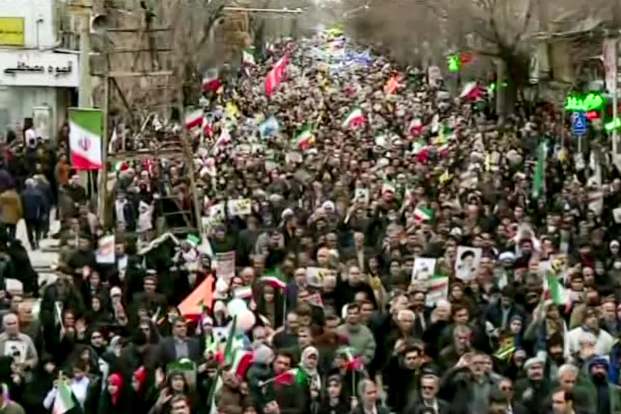 This grab taken from handout video footage released by Iran Press on 11 February 2026 shows people marching in Tehran to mark the 47th anniversary of the 1979 Islamic revolution