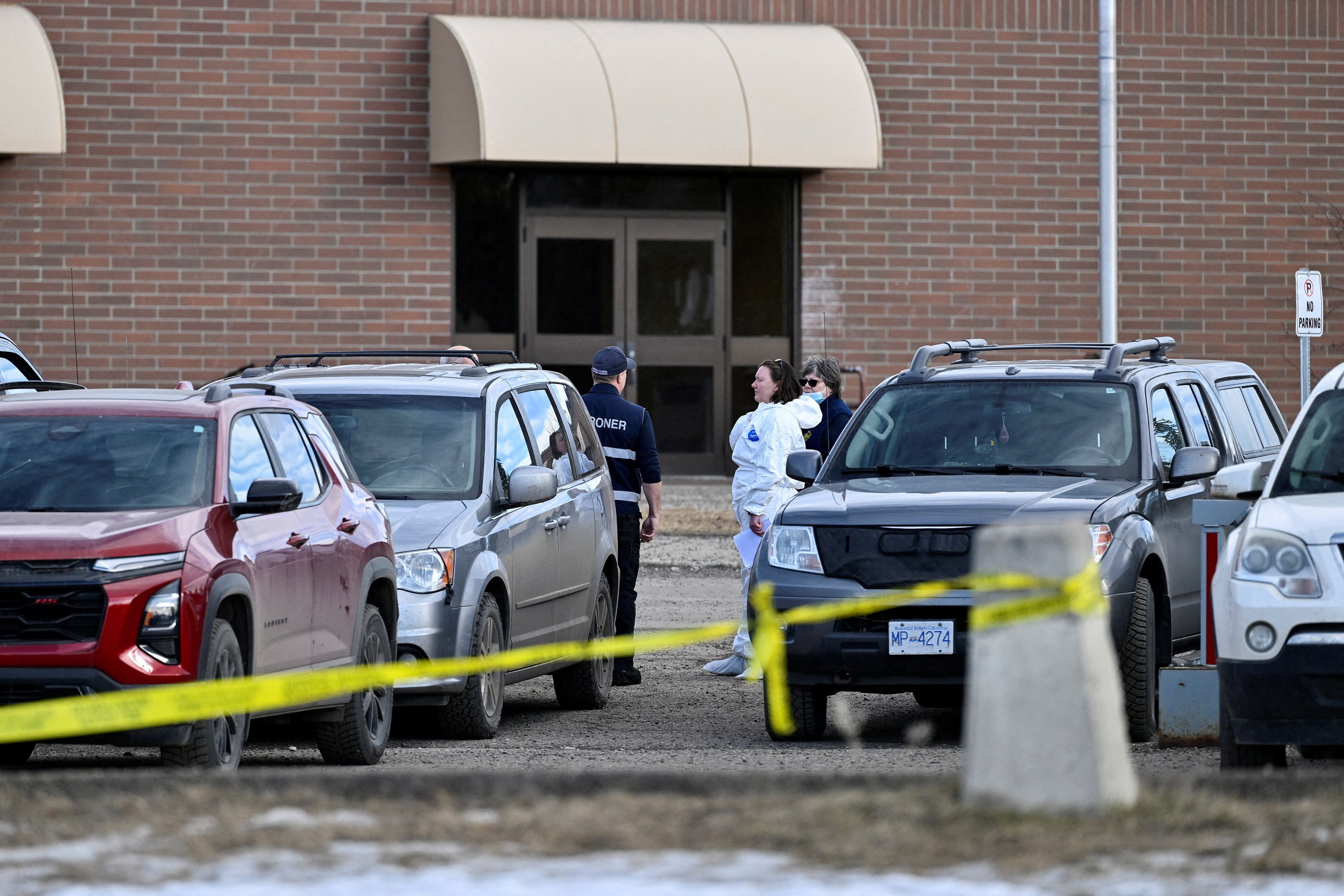 Forensic specialists speak in front of Tumbler Ridge Secondary School, the site of a deadly mass shooting in British Columbia, Canada