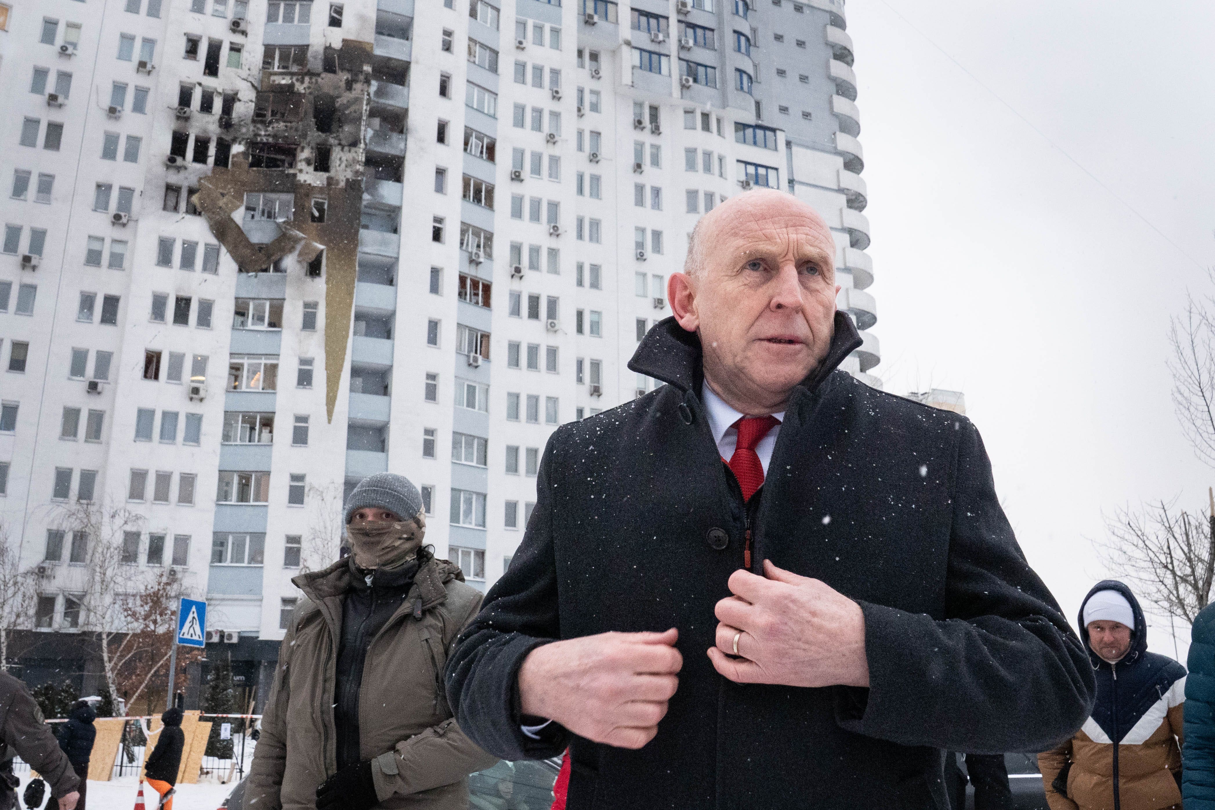 Defence Secretary John Healey meets emergency service workers at the scene of a drone attack which hit a residential area in the east of Kyiv, killing one person (Stefan Rousseau/PA)