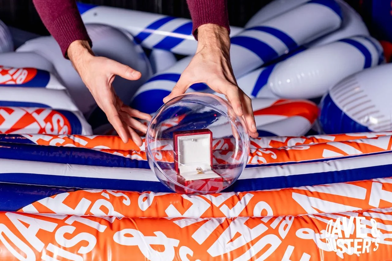 The Human Crane is a $20 life-sized game where players are harnessed and lowered into a pit of oversized prizes