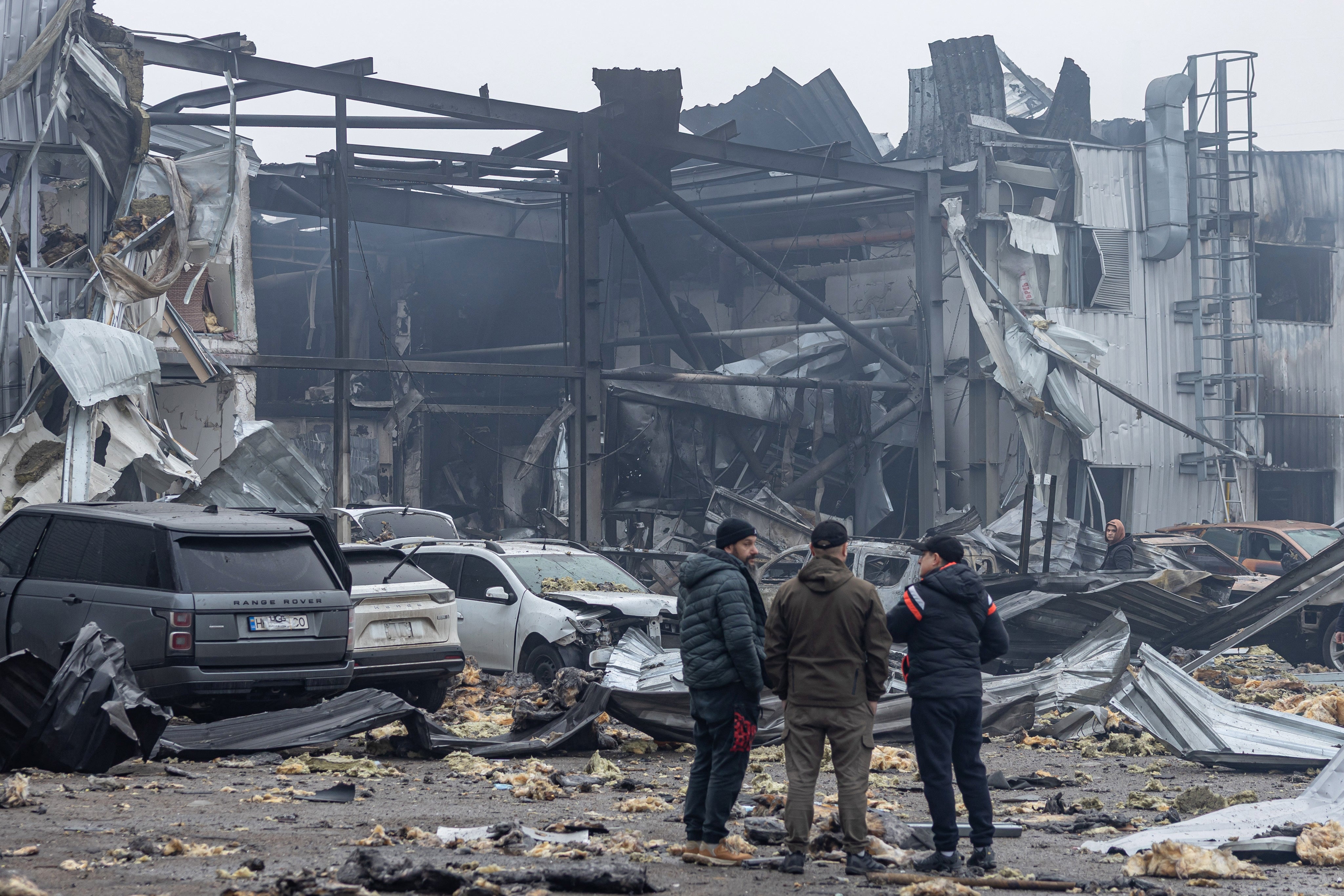 Local residents inspect damaged cars at the site of a Russian attack in Odesa on 13 February