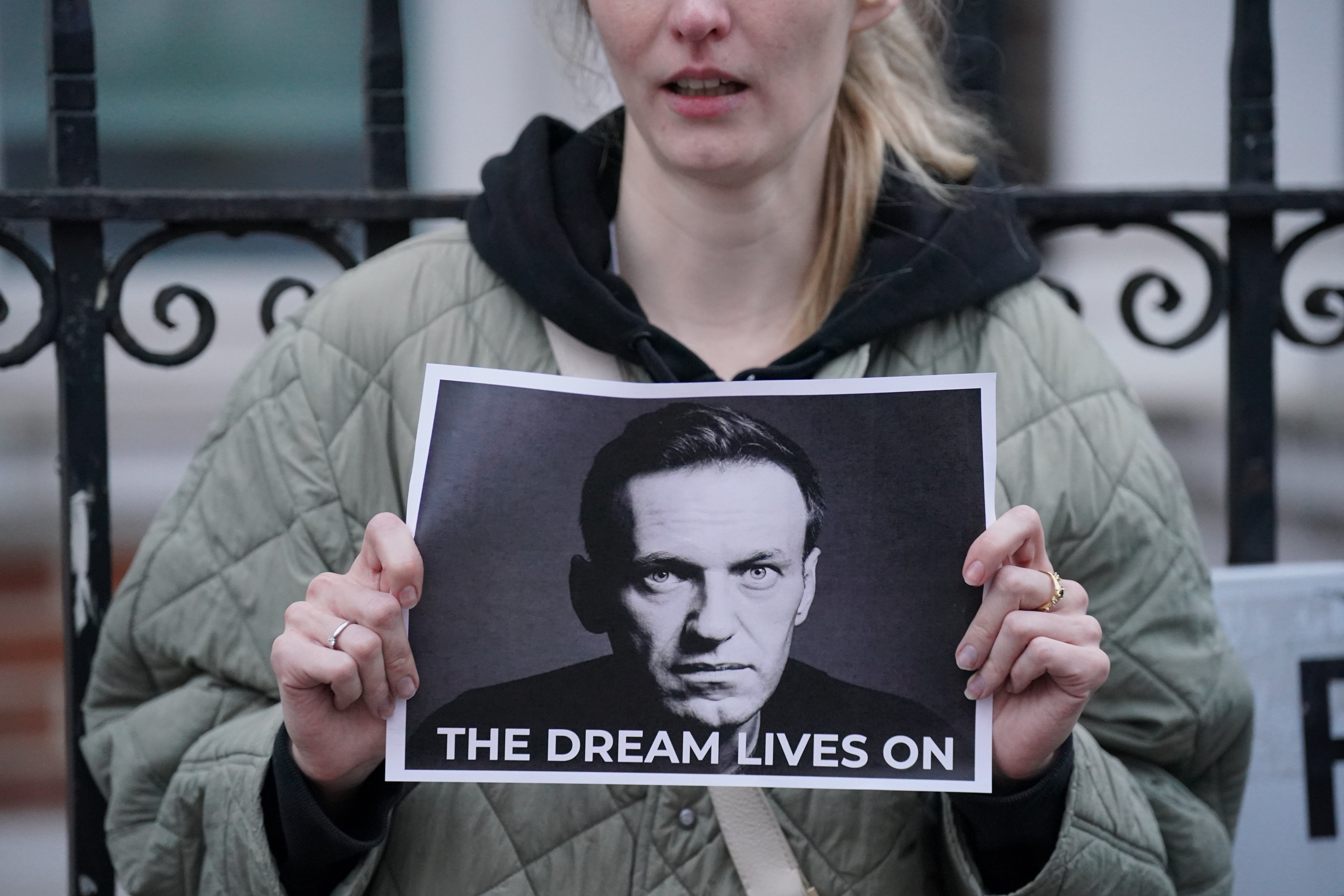 A woman holds a picture of Alexei Navalny, who died two years ago in a Siberian penal colony