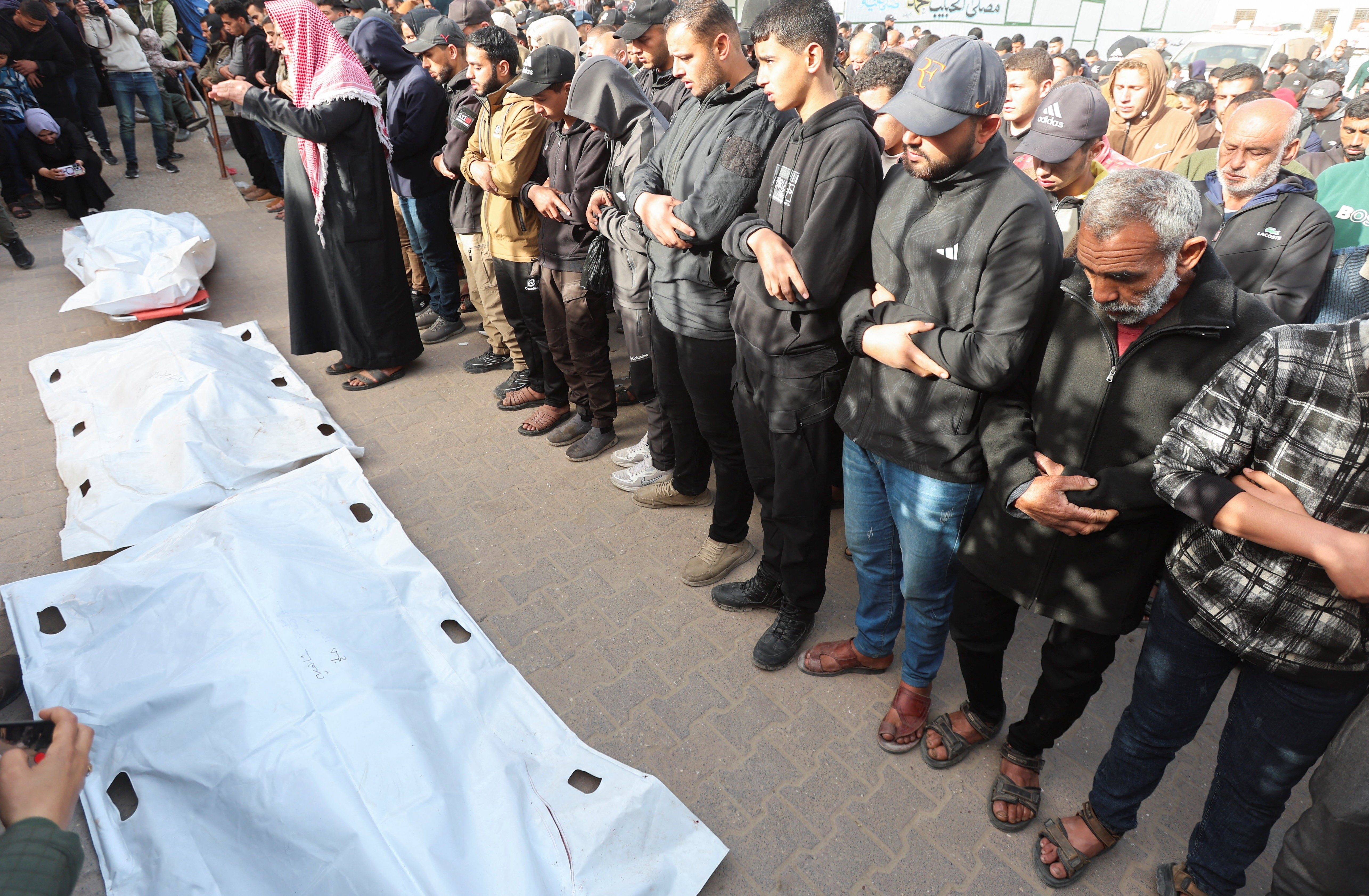 Mourners pray during the funeral of Palestinians killed in an overnight Israeli strike