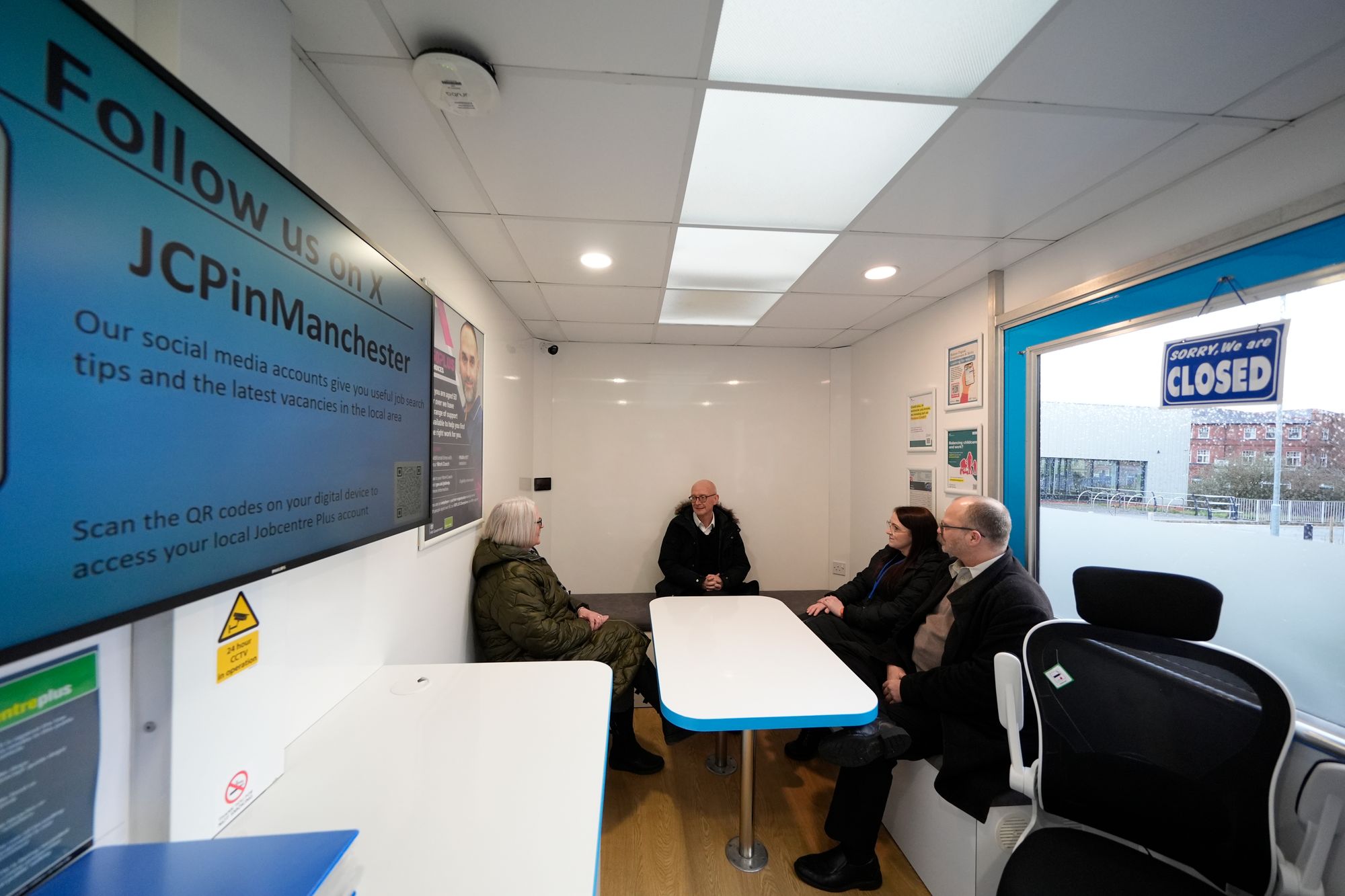 Work and Pensions Secretary Pat McFadden (centre) speaks with Gail Stocks (left), Jen Farrimond and Ian Henderson during a visit to Bolton's 'Jobcentre on Wheels' at Horwich Leisure Centre,