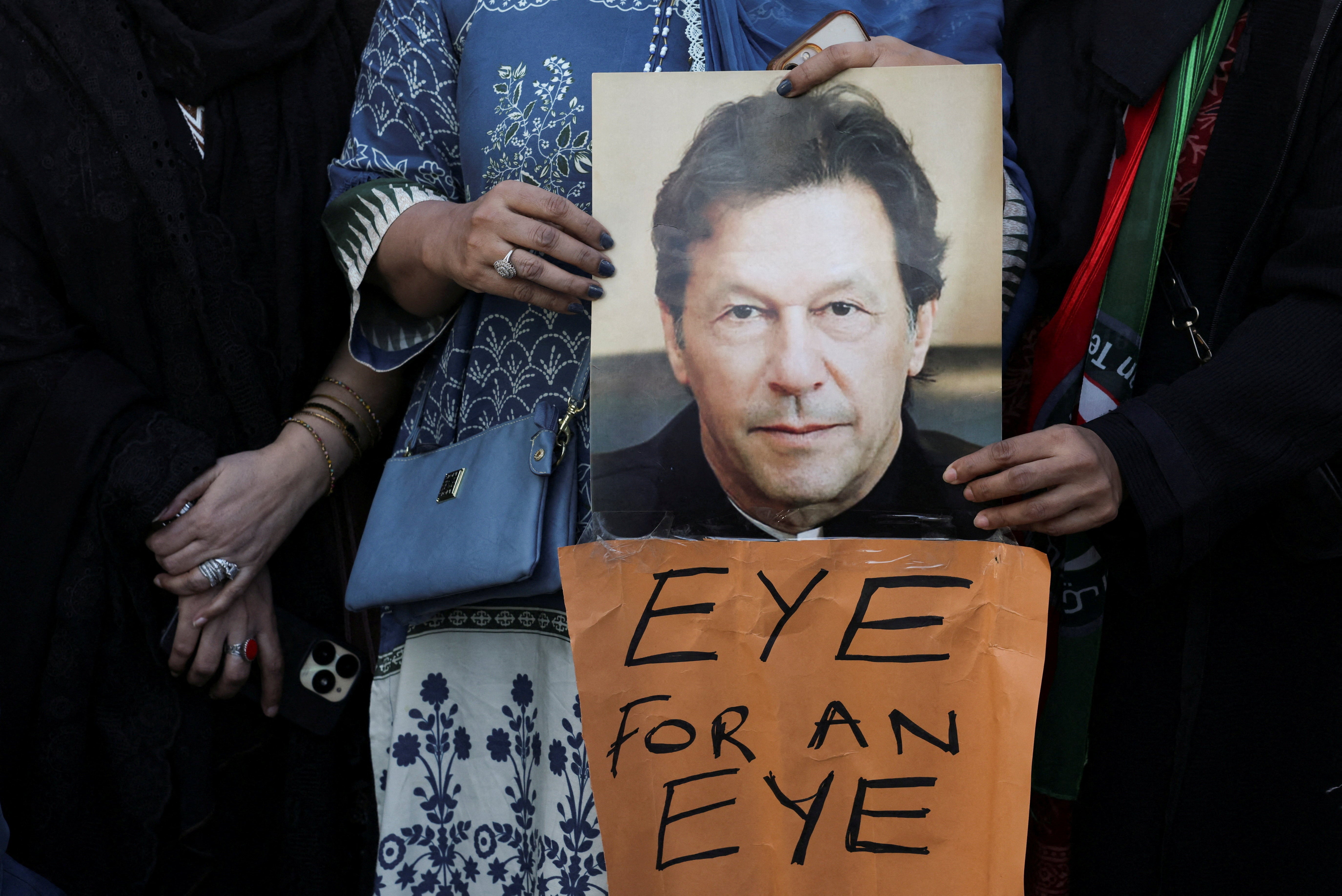 Supporters of jailed former Prime Minister Imran Khan's Pakistan Tehreek-e-Insaf (PTI) party carry a poster of him during a protest over concerns about their leader's health in Karachi, Pakistan