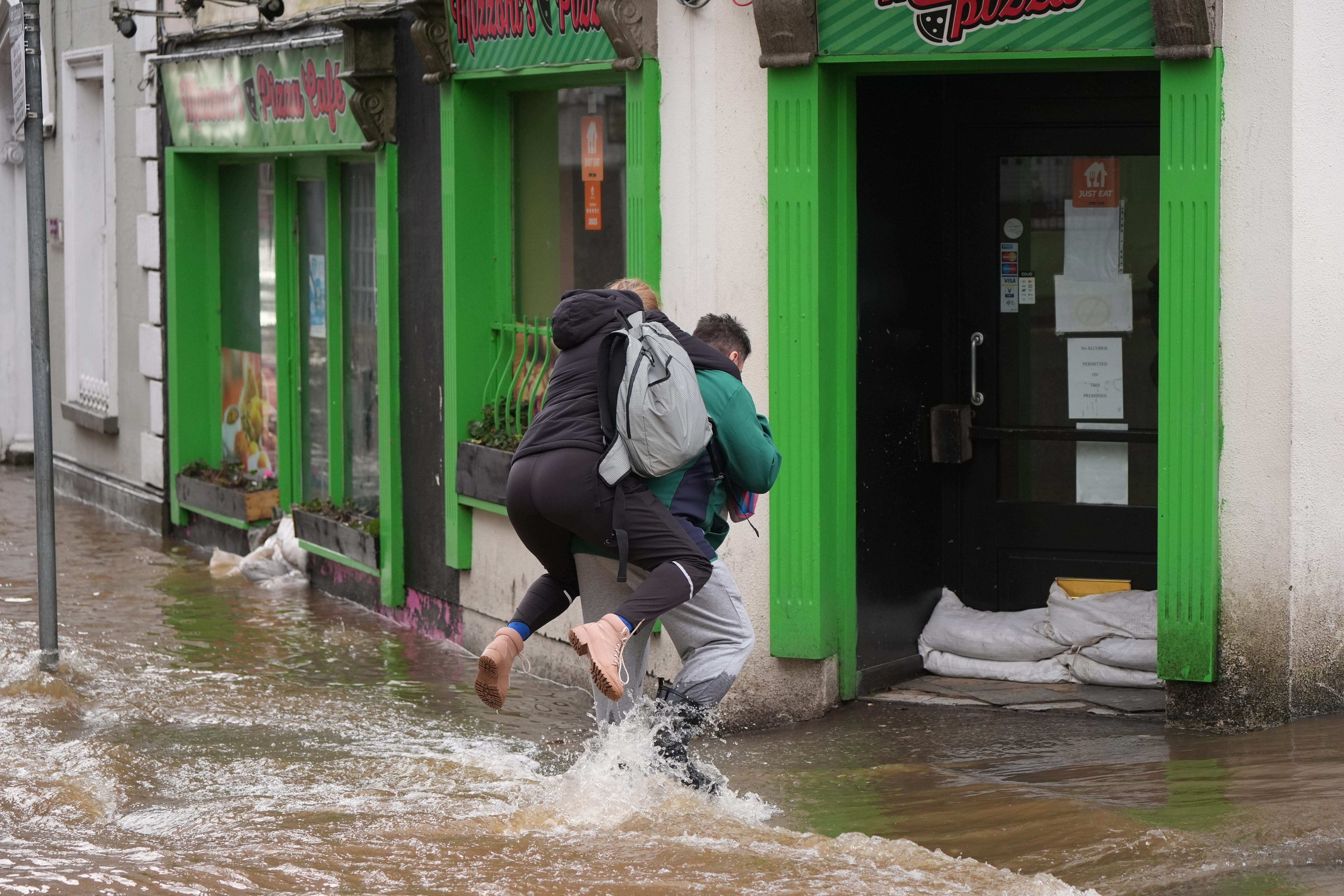 People walking through floodwater in Enniscorthy, Co Wexford, in January (Niall Carson/PA)