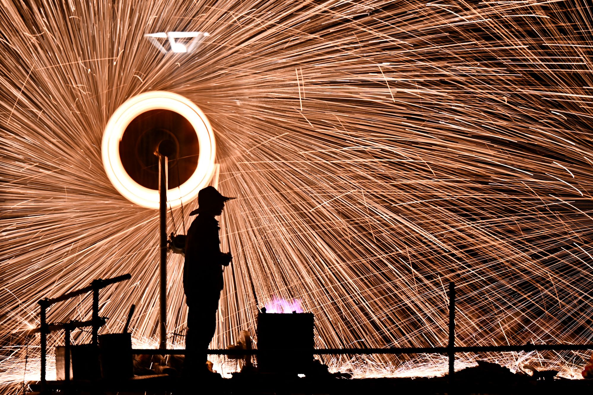 A man performs molten iron fireworks in a park in Beijing on 15 February, 2026 ahead of the Lunar New Year of the Horse