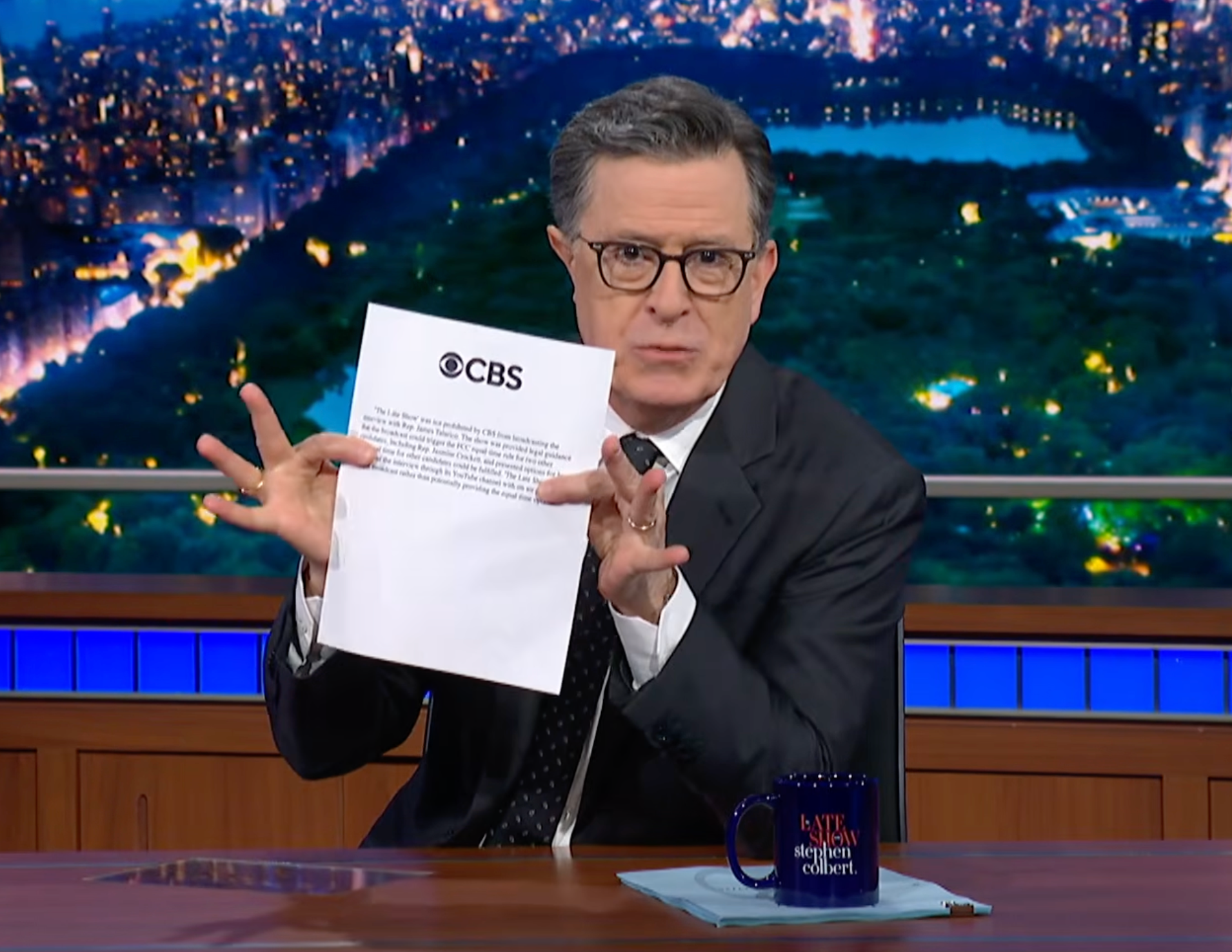 Colbert holds up a printed copy of CBS's statement on Tuesday's instalment of The Late Show