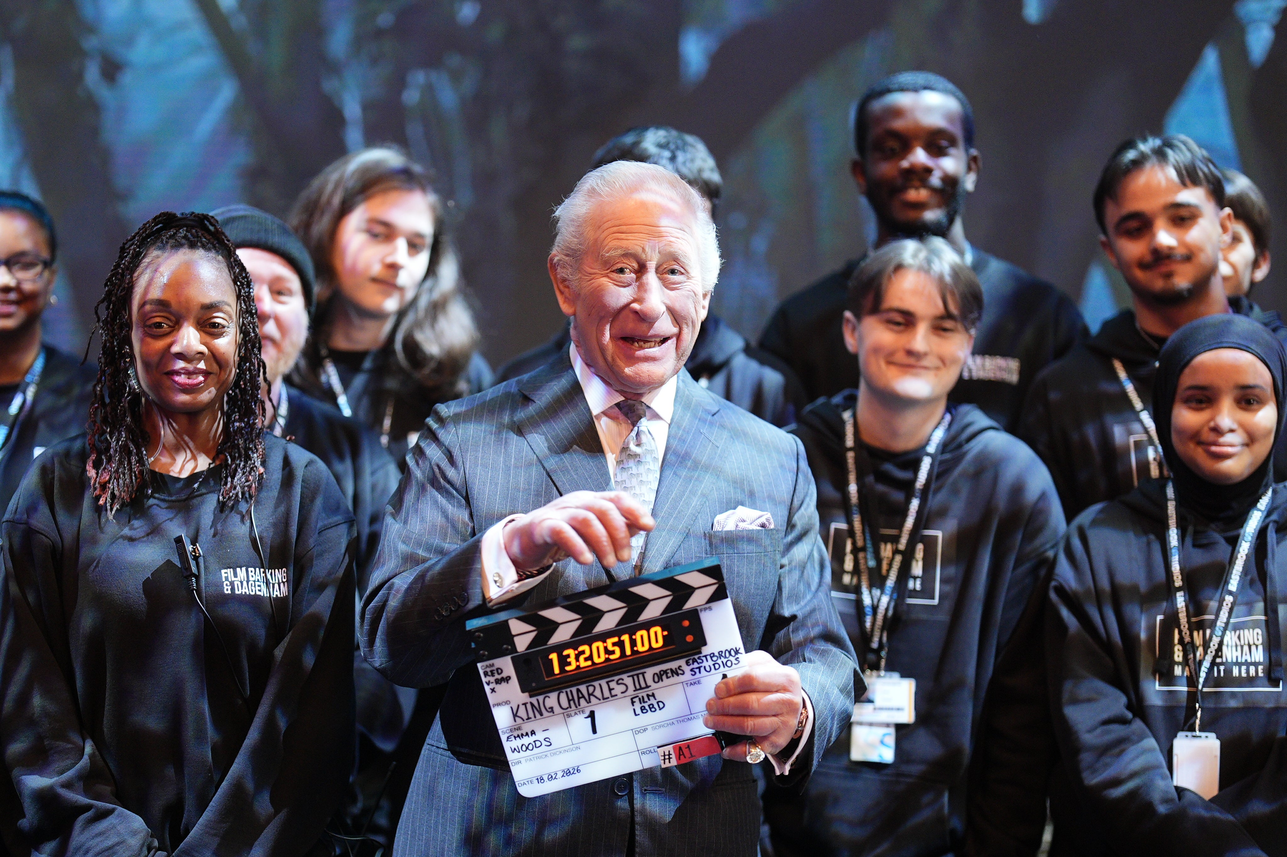 Charles holds a clapperboard during a visit to Eastbrook Studios in Dagenham