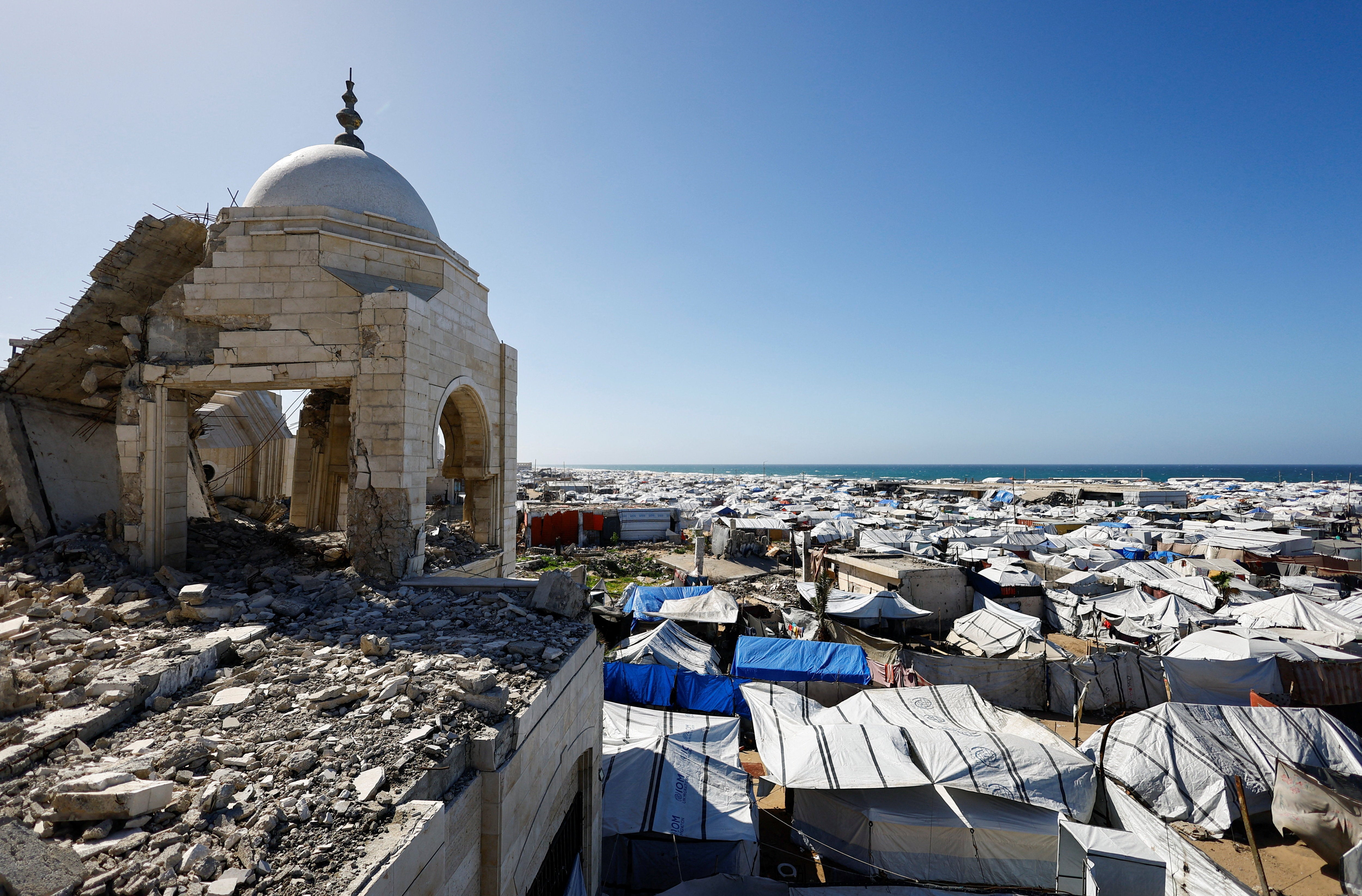 A mosque, damaged during the two-year Israeli offensive, is surrounded by tents for displaced Palestinians in Gaza City