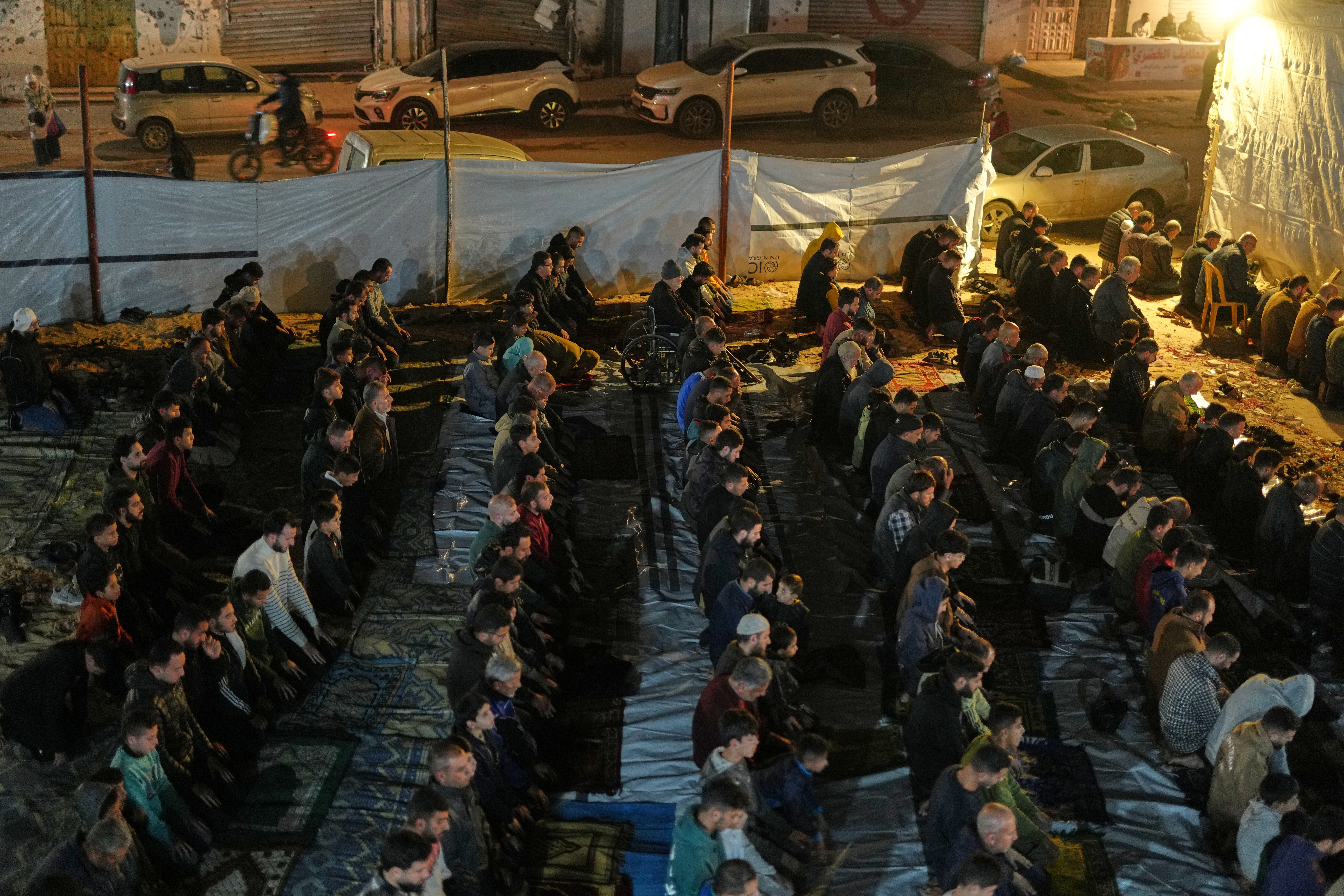 Muslim worshippers perform the evening Tarawih prayer on the first night of Ramadan at the Alkanz Mosque, damaged during the war in Gaza City