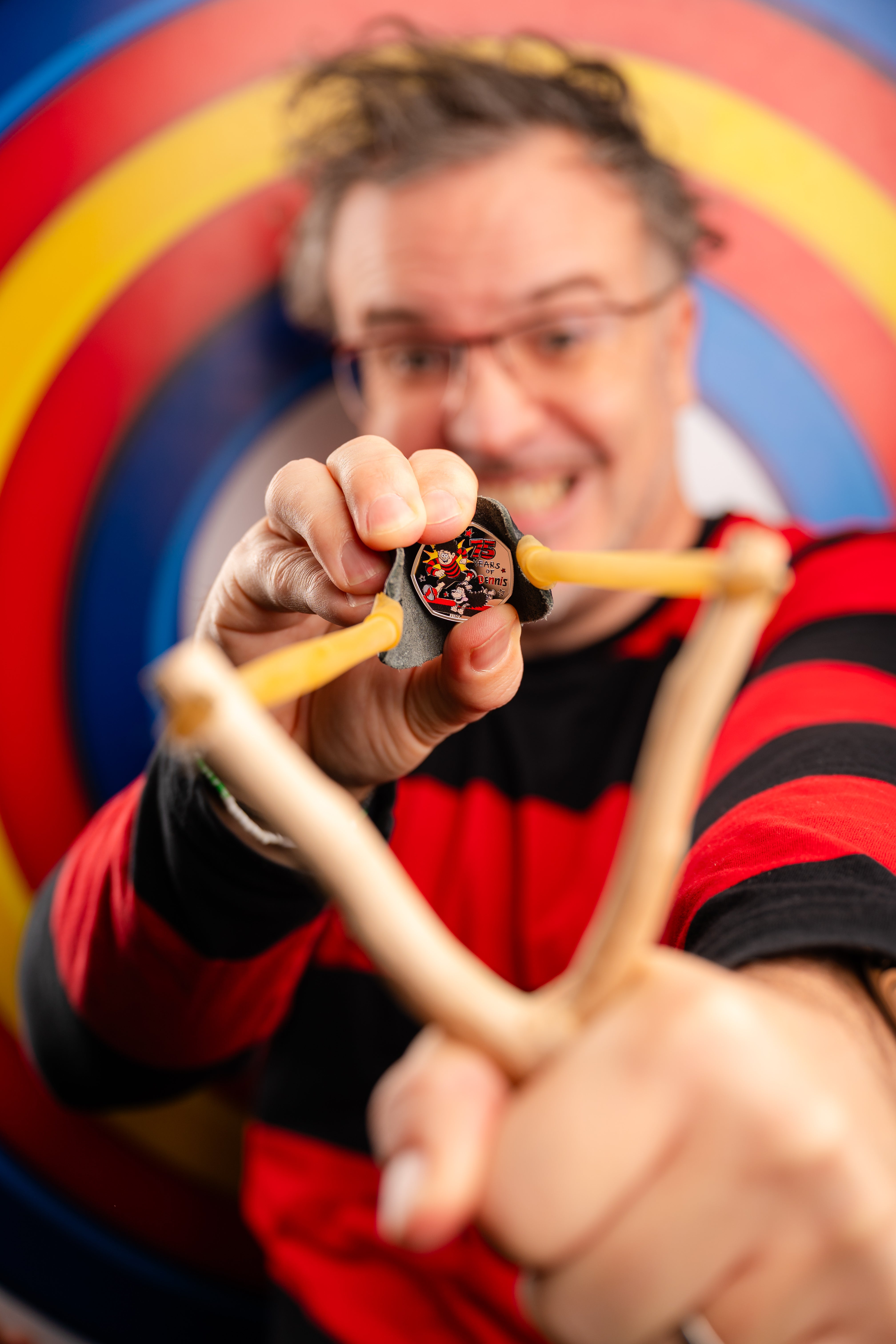 Mike Stirling, director of mischief at Beano, with a Royal Mint Dennis the Menace 50p coin