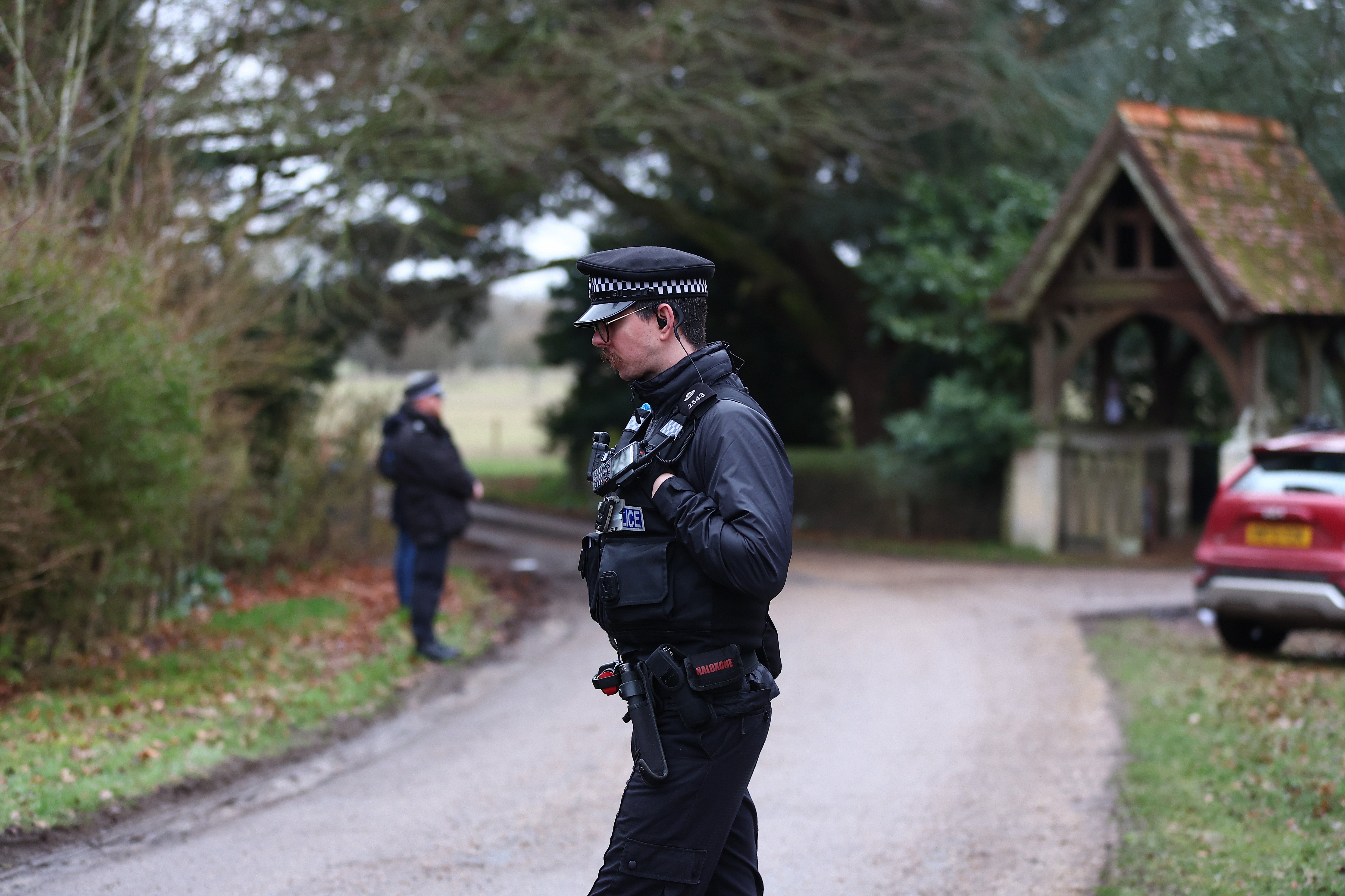Police officers stand guard at the entrance to Mountbatten-Windsor’s home, Wood Farm, in Sandringham