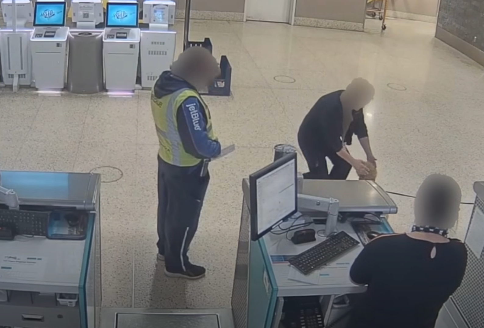 Staff comfort the pup after he was forced to watch his owner walk off into the airport, leaving him behind.