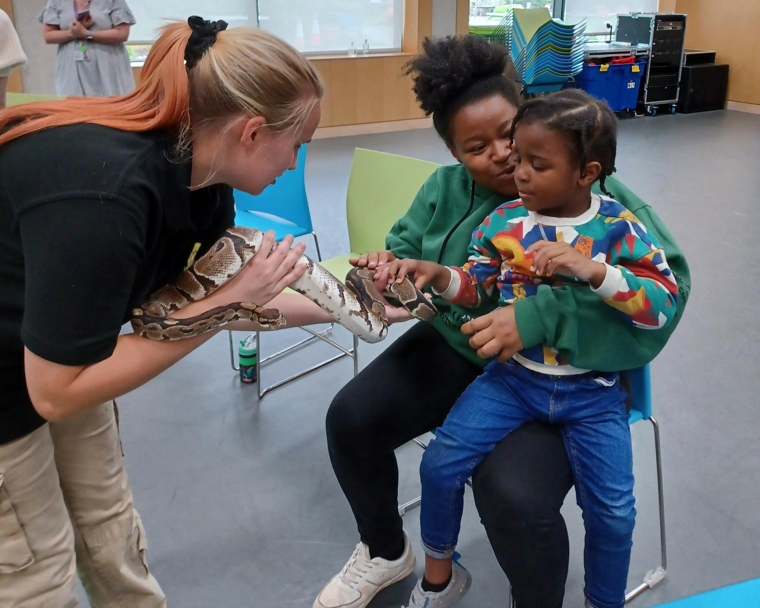 Natalie and Azuriah interact with a snake at a Sense play session