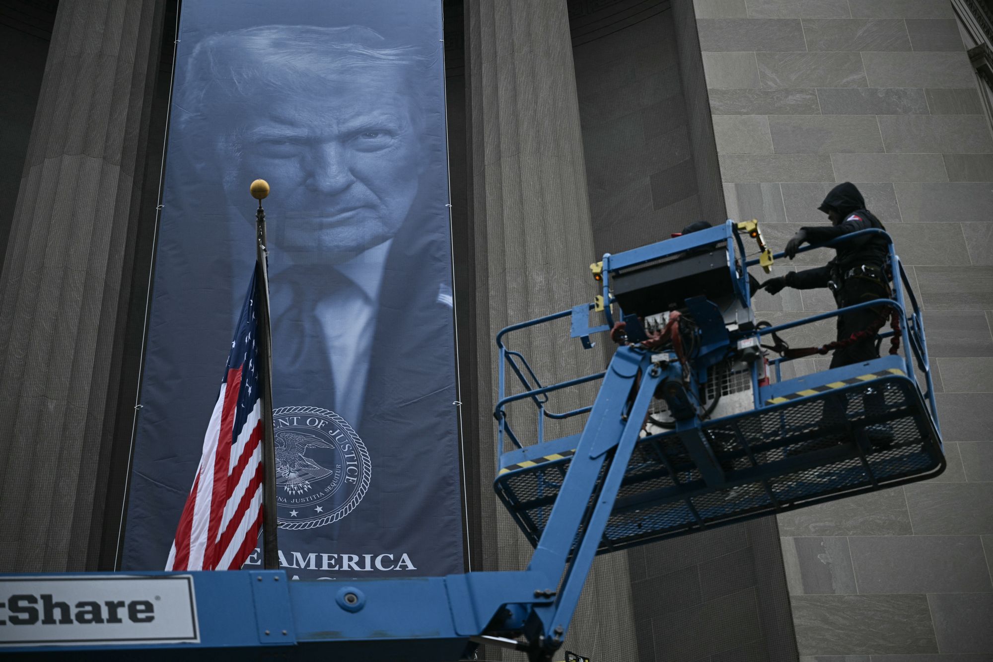 Critics of the president were alarmed on Thursday after workers installed a huge banner of Trump on the headquarters of the Department of Justice