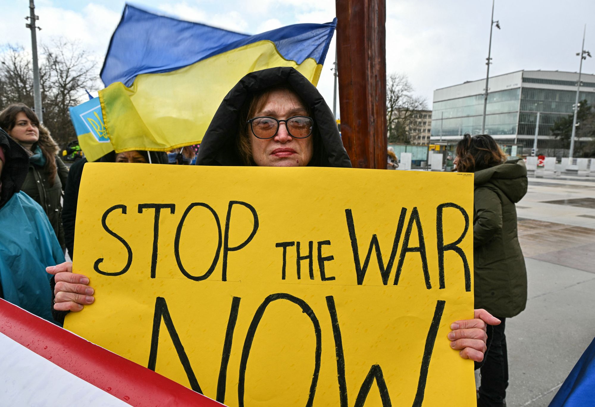 A protester holds a placard as a new round of talks between Russian, Ukrainian and US negotiators aimed at finding a solution to four years of fighting in Ukraine, takes place in Geneva 