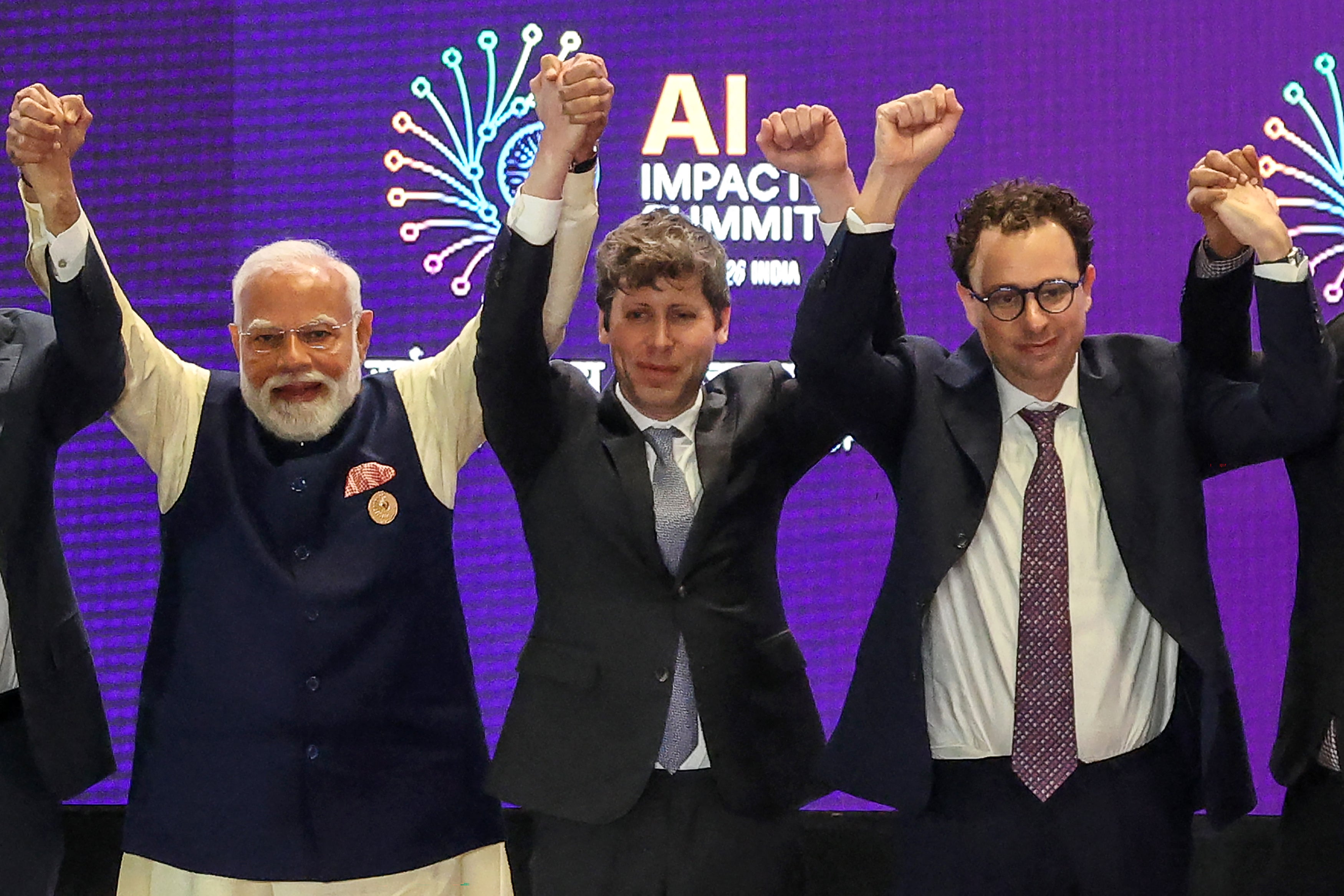 India's Prime Minister Narendra Modi (L) takes a group photo with AI company leaders including OpenAI CEO Sam Altman (C) and Anthropic CEO Dario Amodei (R) at the AI Impact Summit in New Delhi