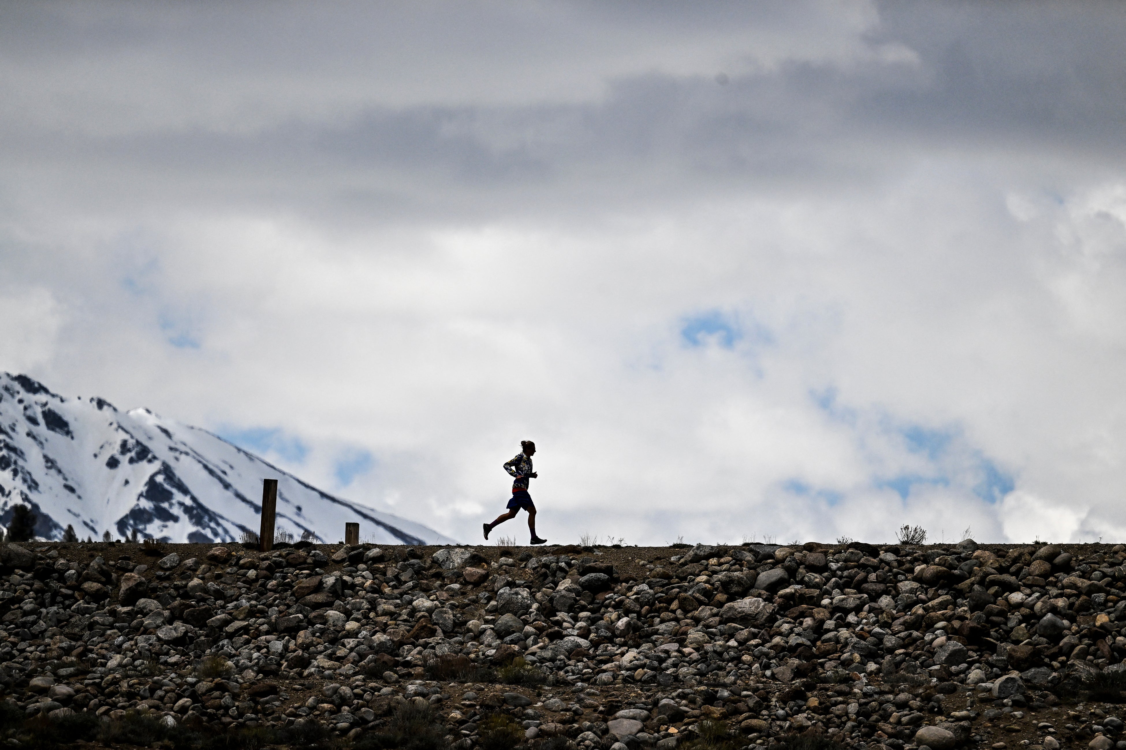 US ultramarathon runner Courtney Dauwalter runs over a dam near Twin Lakes, Colorado