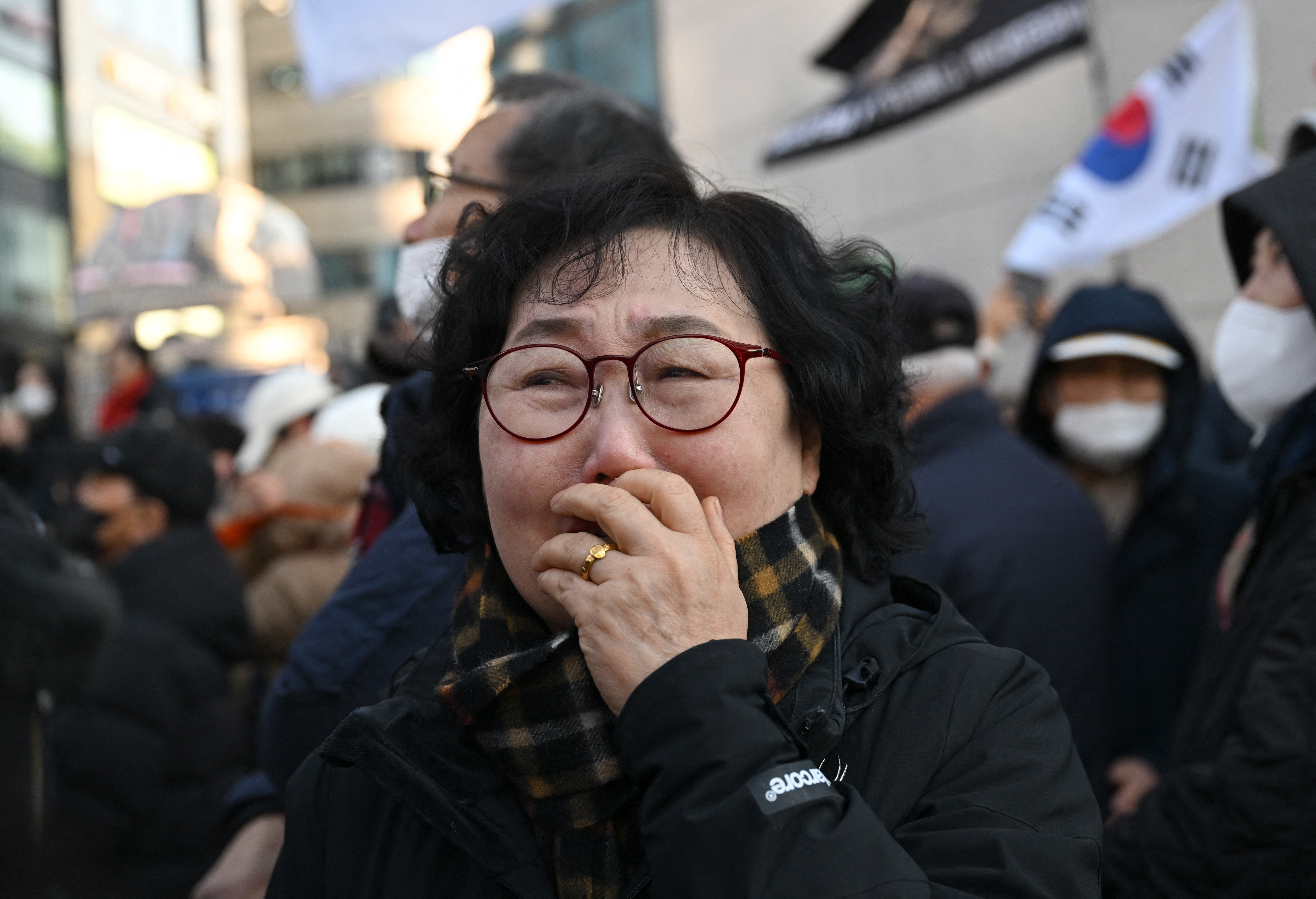 Supporters of South Korea’s impeached former president Yoon Suk Yeol react as they watch a live stream of his trial in Seoul on 19 February 2026