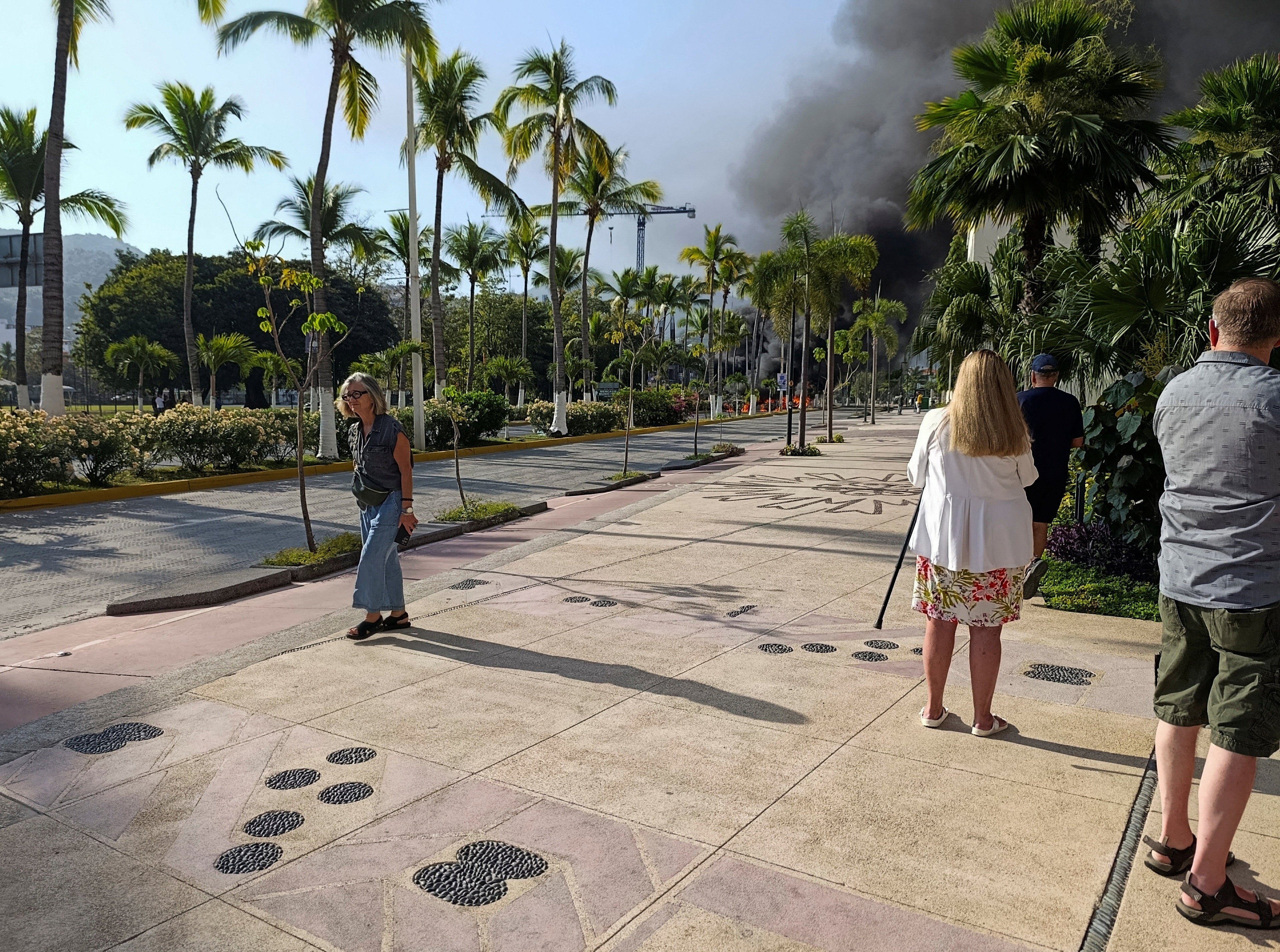 Tourists in Puerto Vallarta watch plumes of smoke above the tourist-heavy coastal city as drug gangs retaliate in the wake of a military operation against notorious trafficker El Mencho