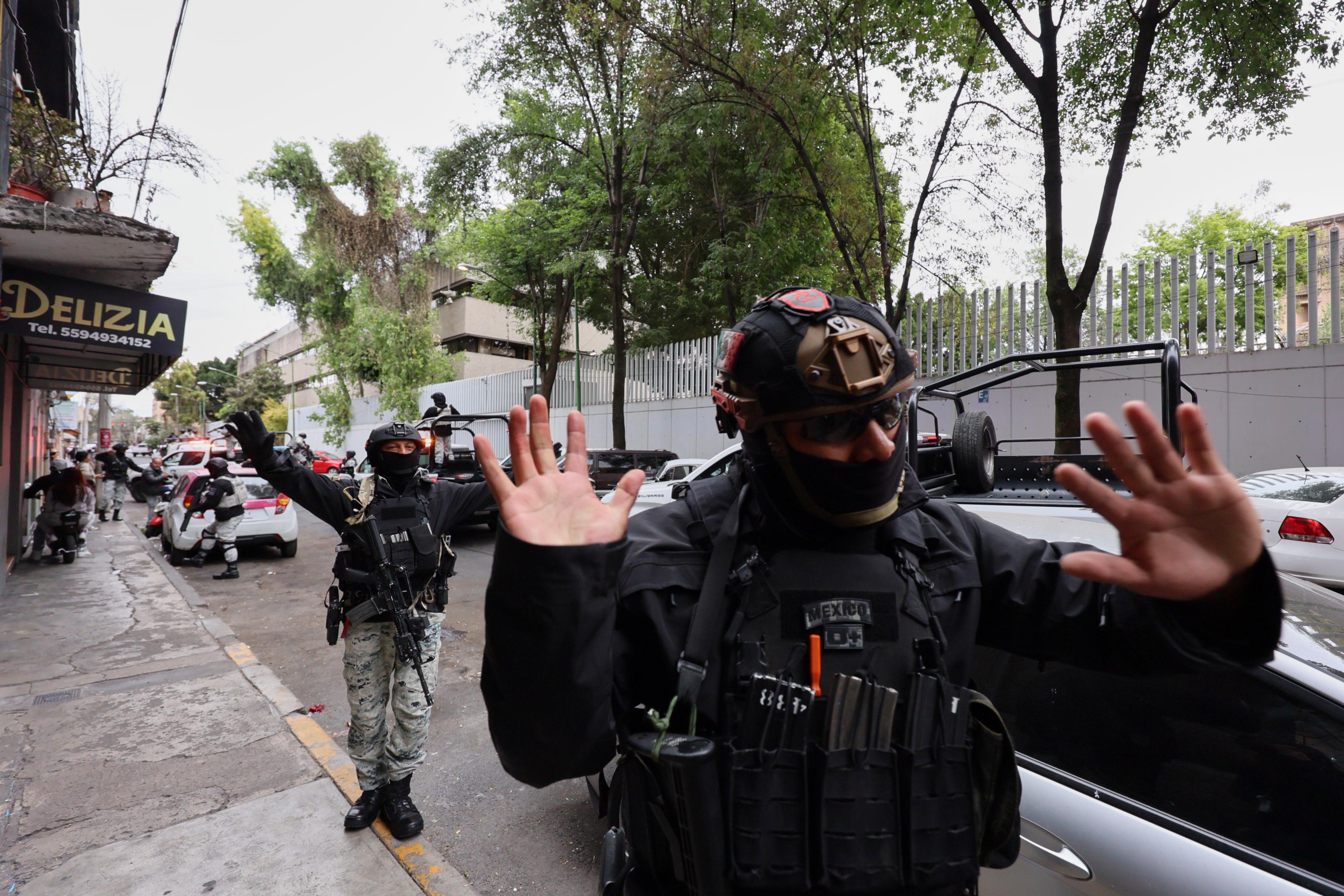National Guards remove pedestrians by the General Prosecutor's headquarters in Mexico City, Sunday, Feb. 22, 2026, after the death of the leader of the Jalisco New Generation Cartel, Nemesio Rubén Oseguera Cervantes, known as "El Mencho." (AP Photo/Ginette Riquelme)