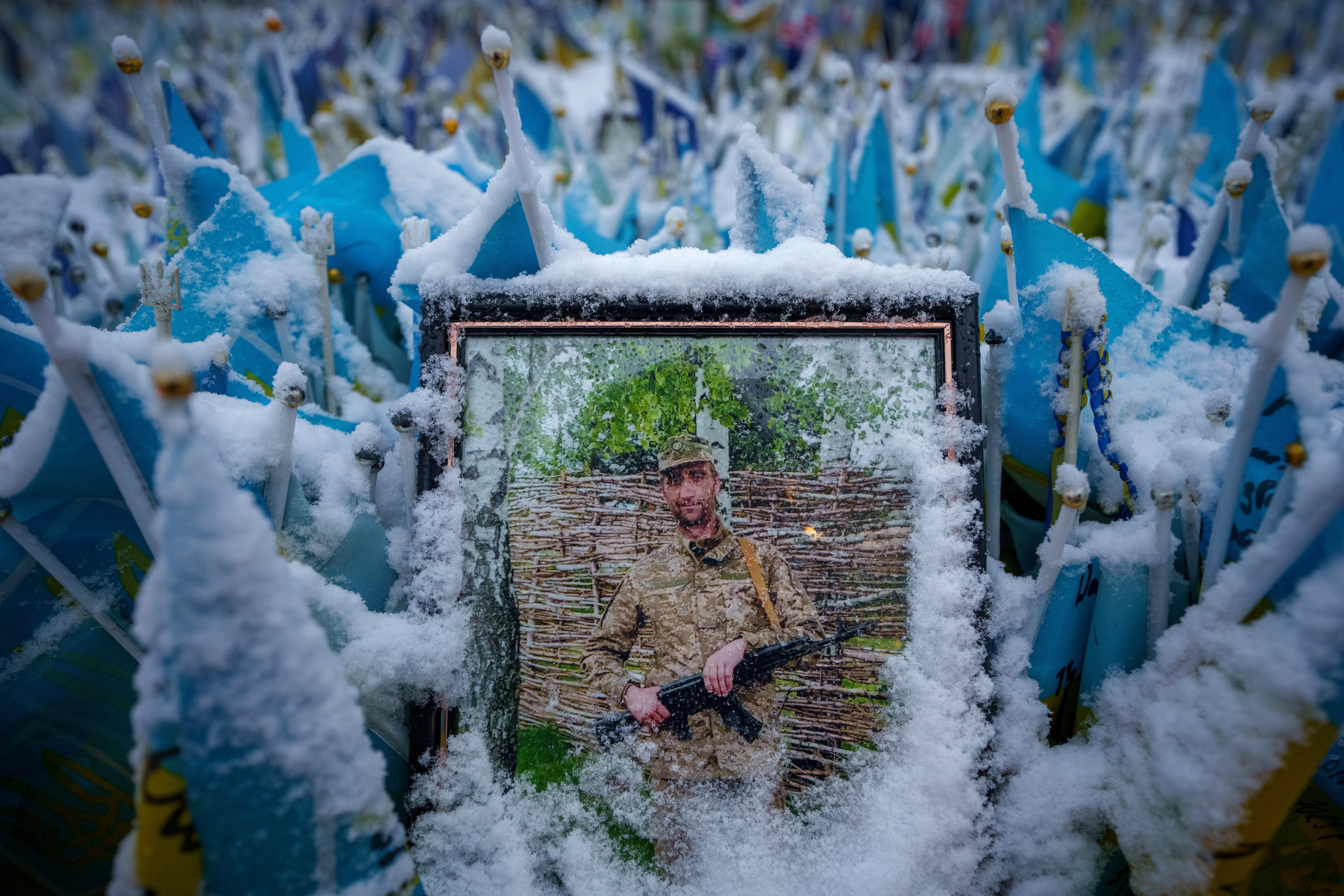 nowflakes cover the photograph of a fallen Ukrainian serviceman in downtown Kyiv, Ukraine.