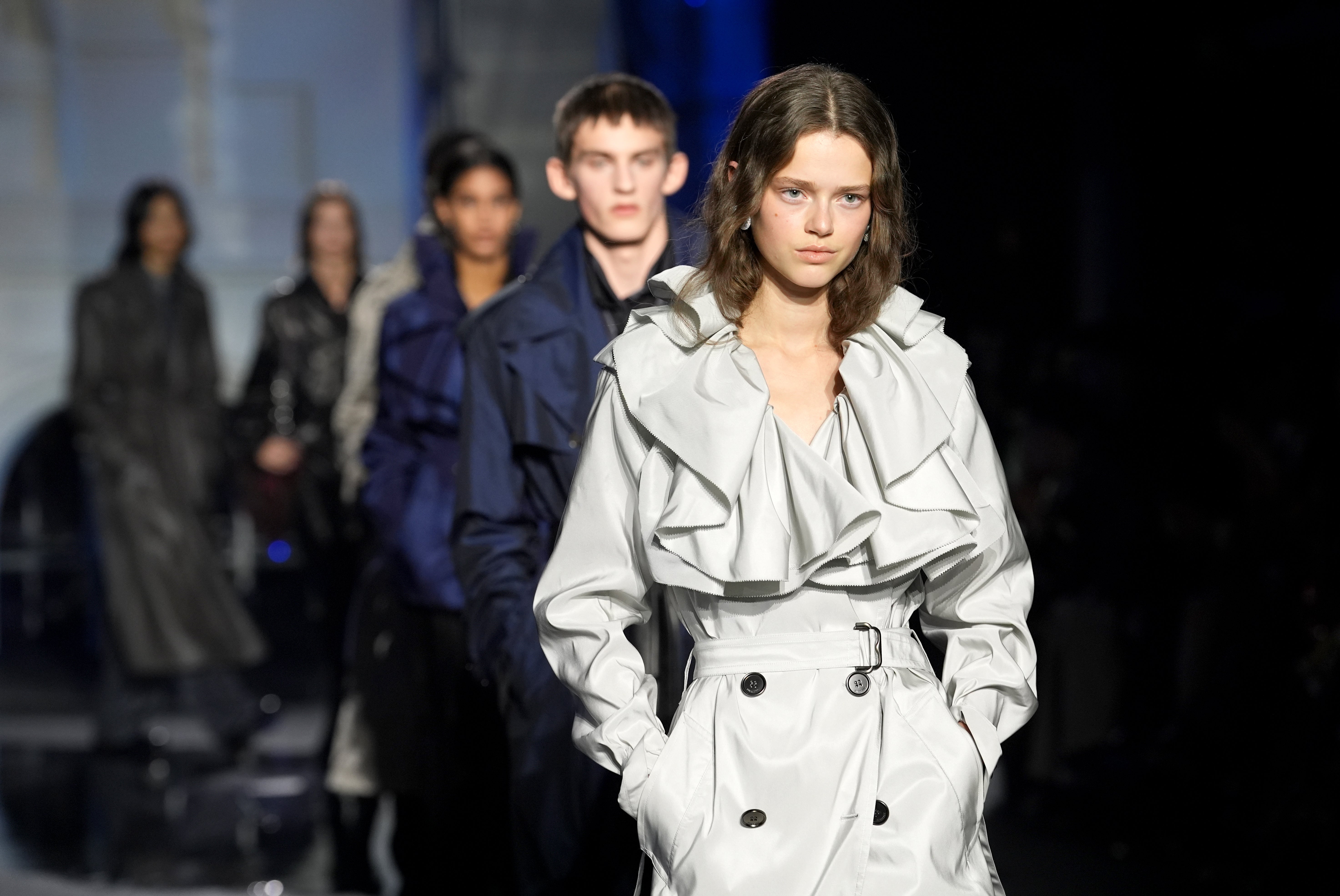 Romantic ruffles emerged at the collars of several pieces, softening the utilitarian edge of leather and aviation references