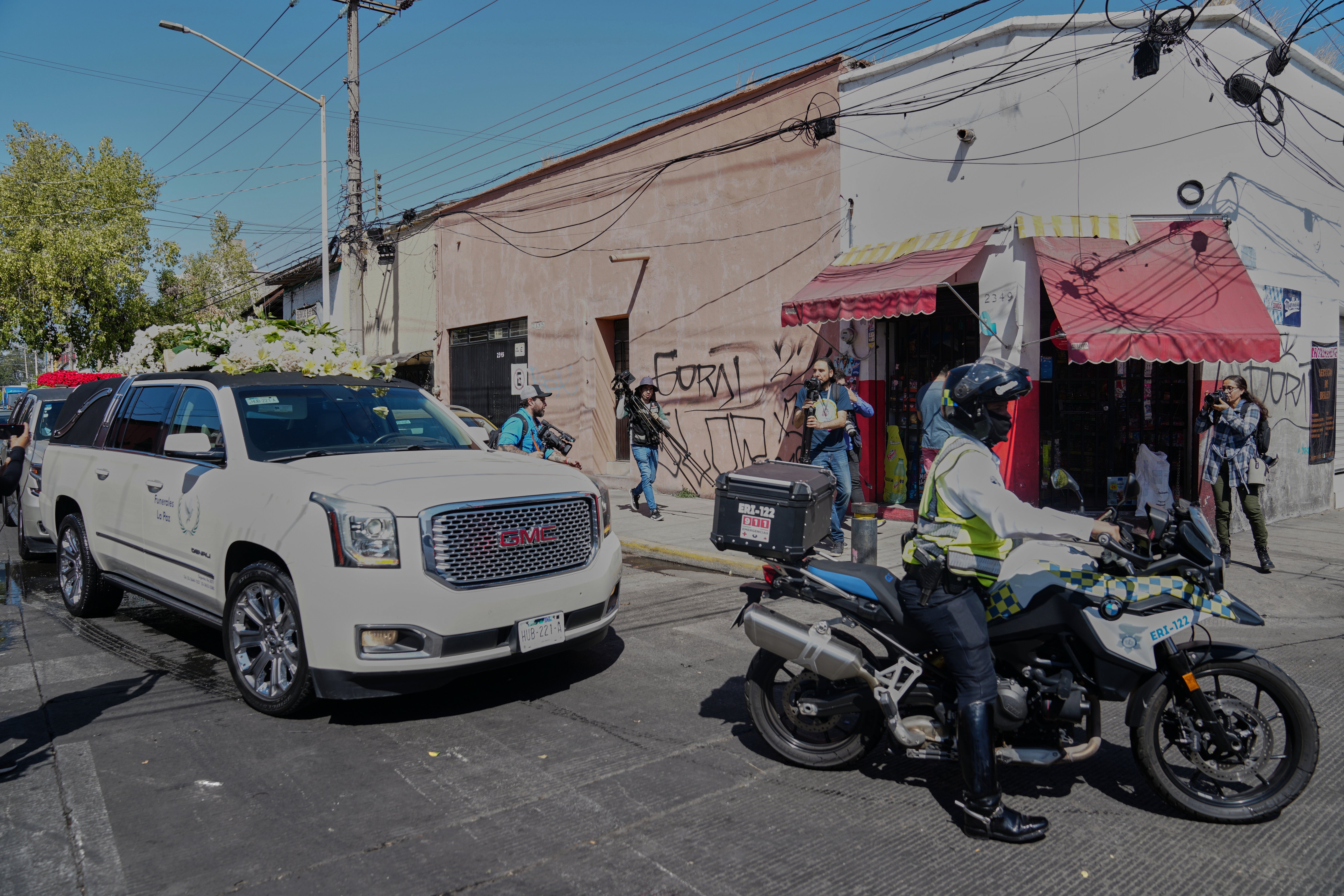 A constabulary serviceman escorts nan car to nan Recinto de Paz cemetery for funeral successful Guadalajara, Mexico