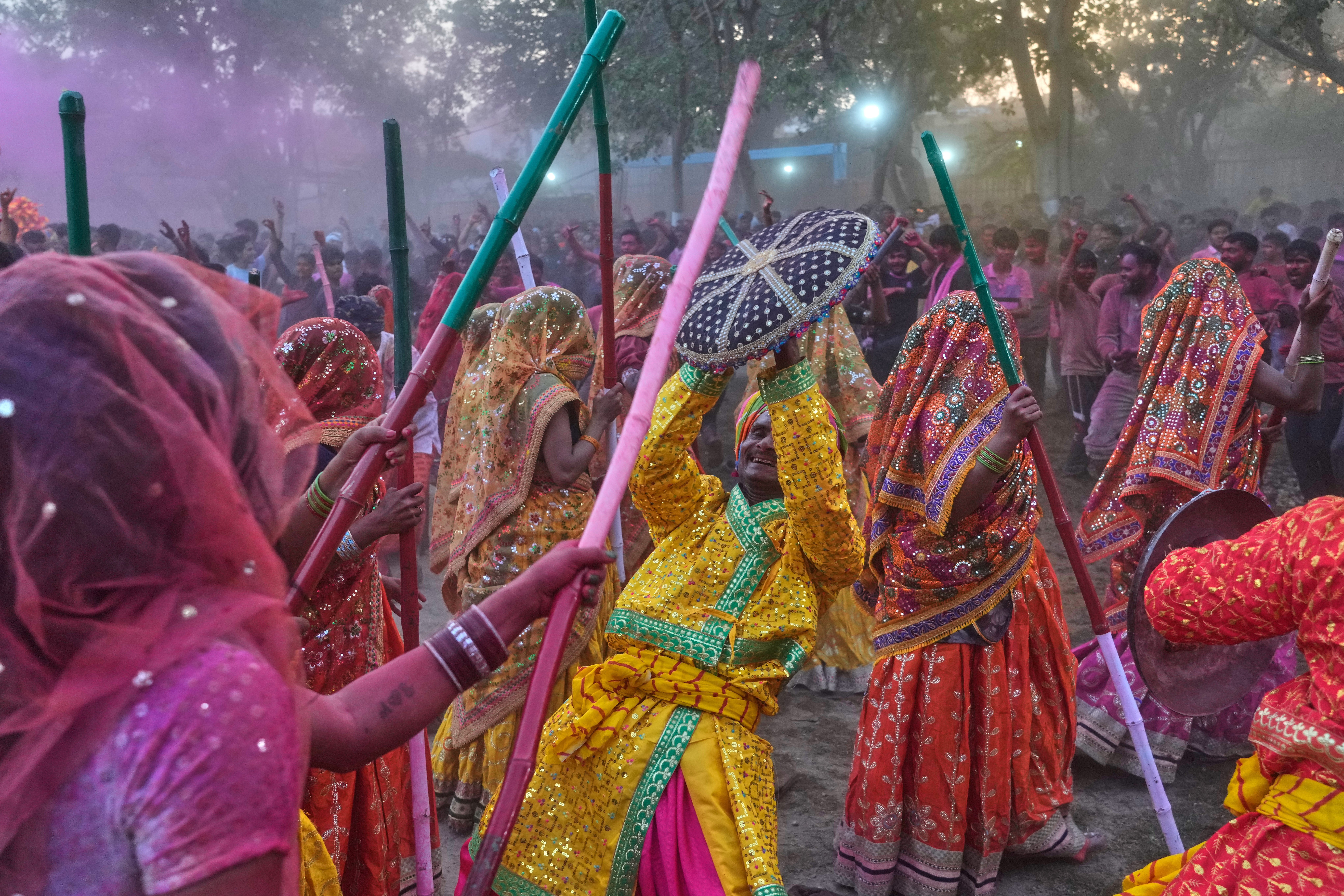 Women devotees symbolically beat men with wooden sticks to mark Lathmar Holi during Holi festival celebrations at the Shri Krishna Janmabhoomi Temple complex in Mathura, India