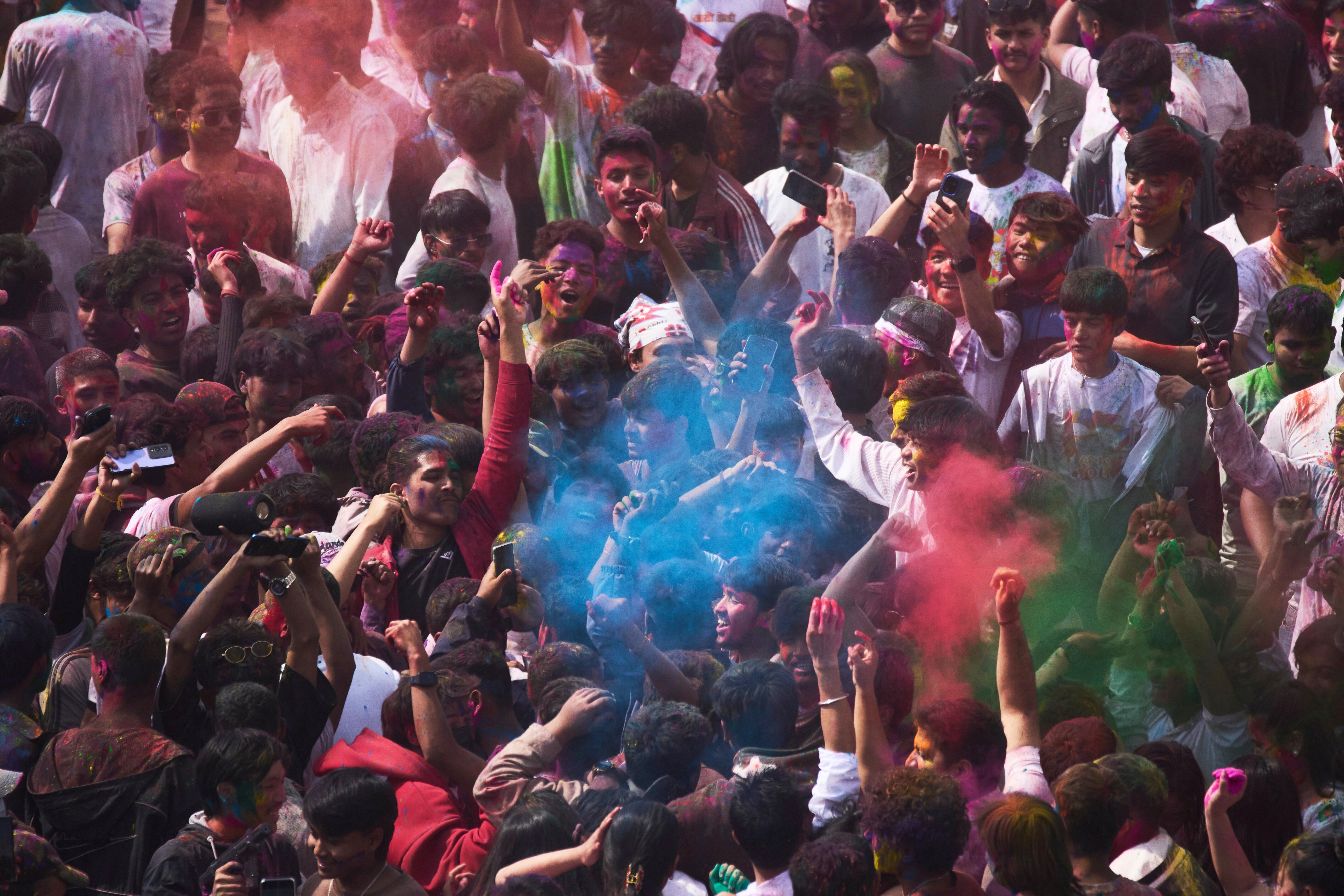 Nepalese people throw colored powders on each other as they celebrate Holi, the Hindu festival of colors at Basantapur Durbar Square in Kathmandu, Nepal