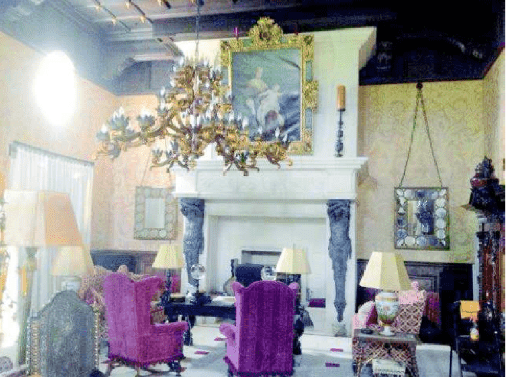 The 'Great Room' astatine Zorro Ranch, seen pinch an oversized fireplace, elaborate chandelier and purple wingback chairs