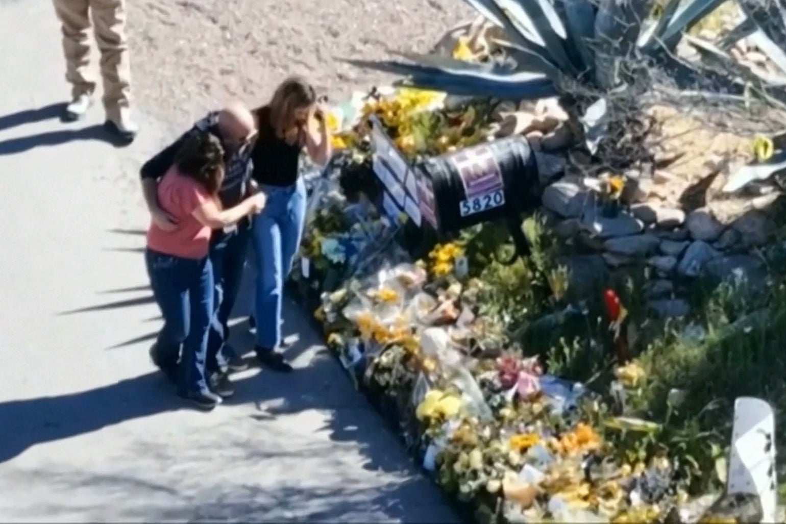 Savannah Guthrie, right, her sister Annie Guthrie, left, and her brother-in-law Tommaso Cioni, visiting a tribute to their mother Nancy Guthrie outside her home on March 2