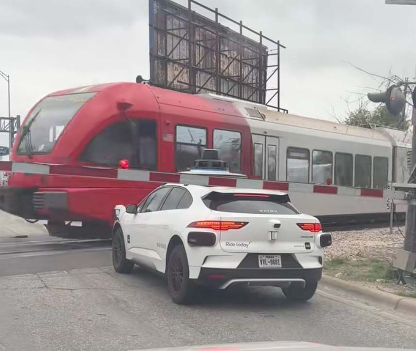 Terrifying moment Waymo stops between railway tracks and stop arm as train passes by inches away