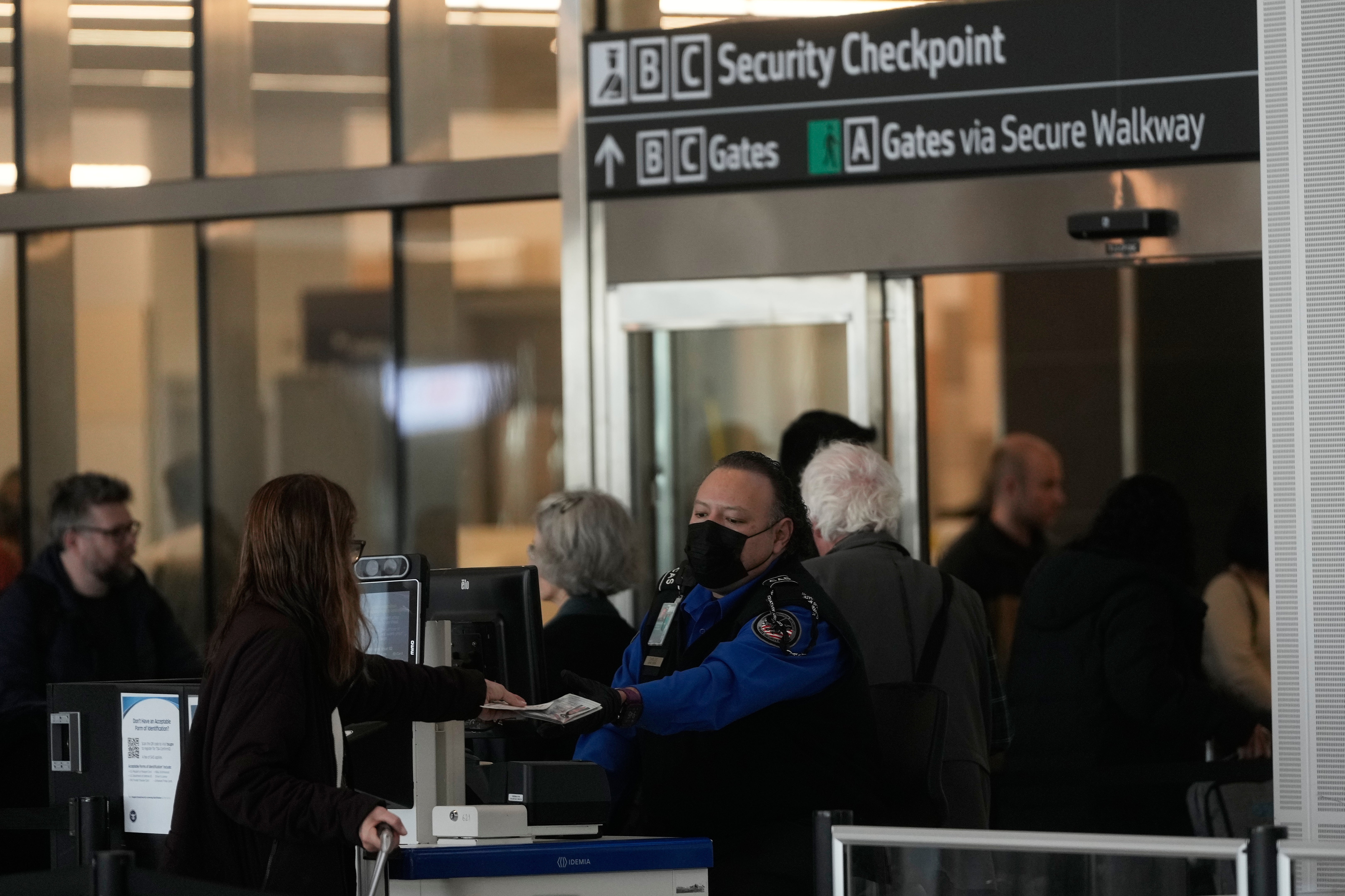 A Covenant Aviation Security Private Security Services supplier checks successful a rider astatine a information gate.