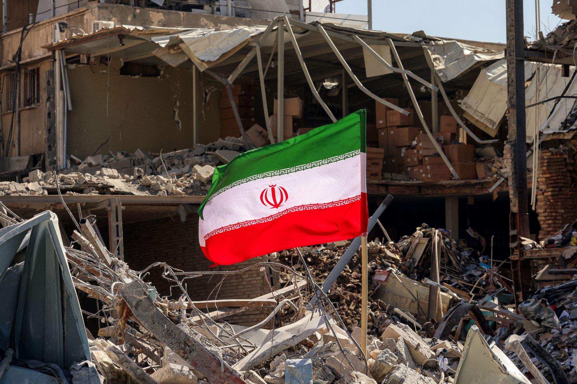 An Iranian emblem flying amid nan rubble of fallen buildings successful Tehran pursuing associated U.S.-Israeli airstrikes this month