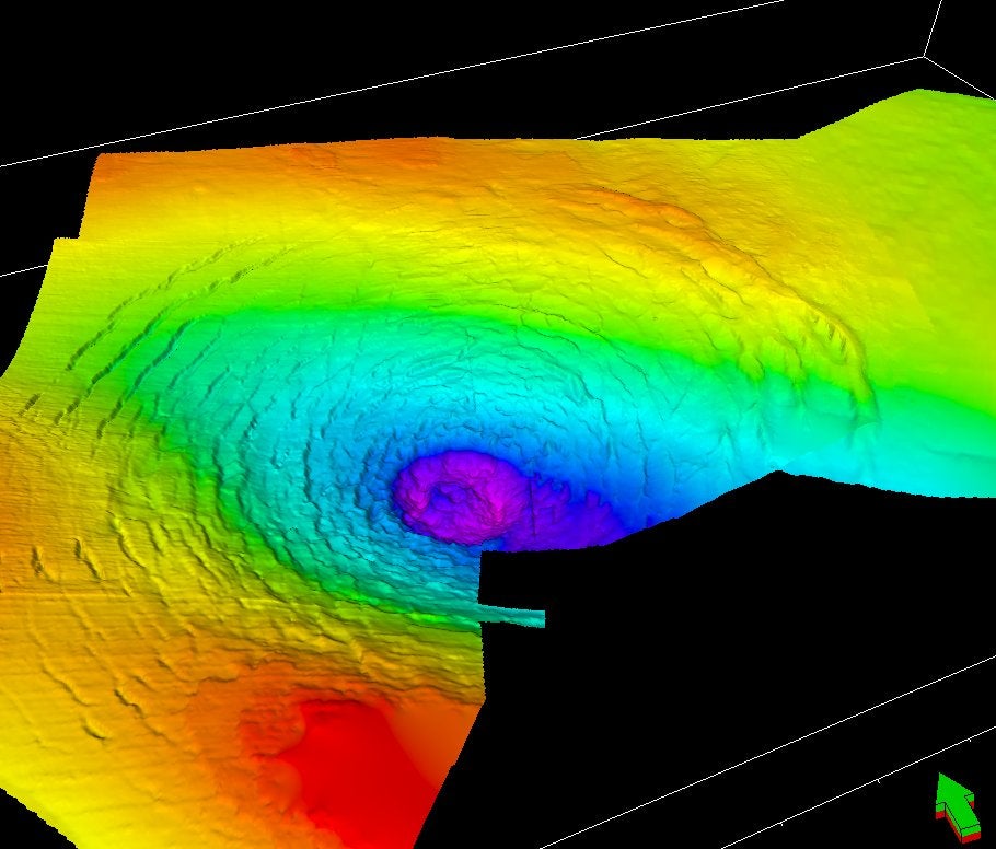 A perspective view of the top chalk surface, looking northeast, showing the central crater and its surrounding rings. False colours indicate depth (red/yellow = shallow; blue/purple = deep)