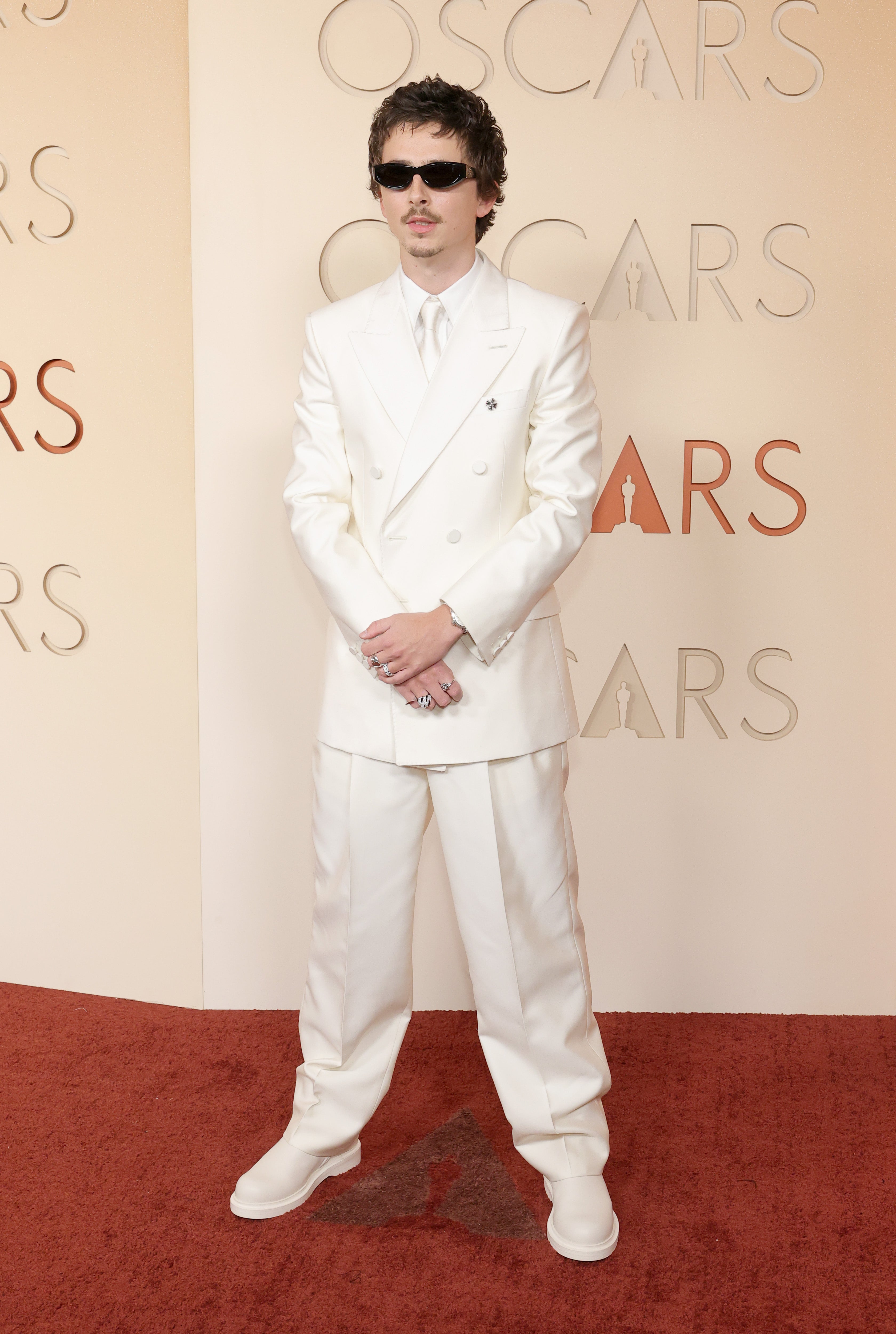 The ‘Marty Supreme’ actor stunned on the red carpet in his all-white suit — until he randomly threw on a pair of black sunglasses and power-posed for a photo