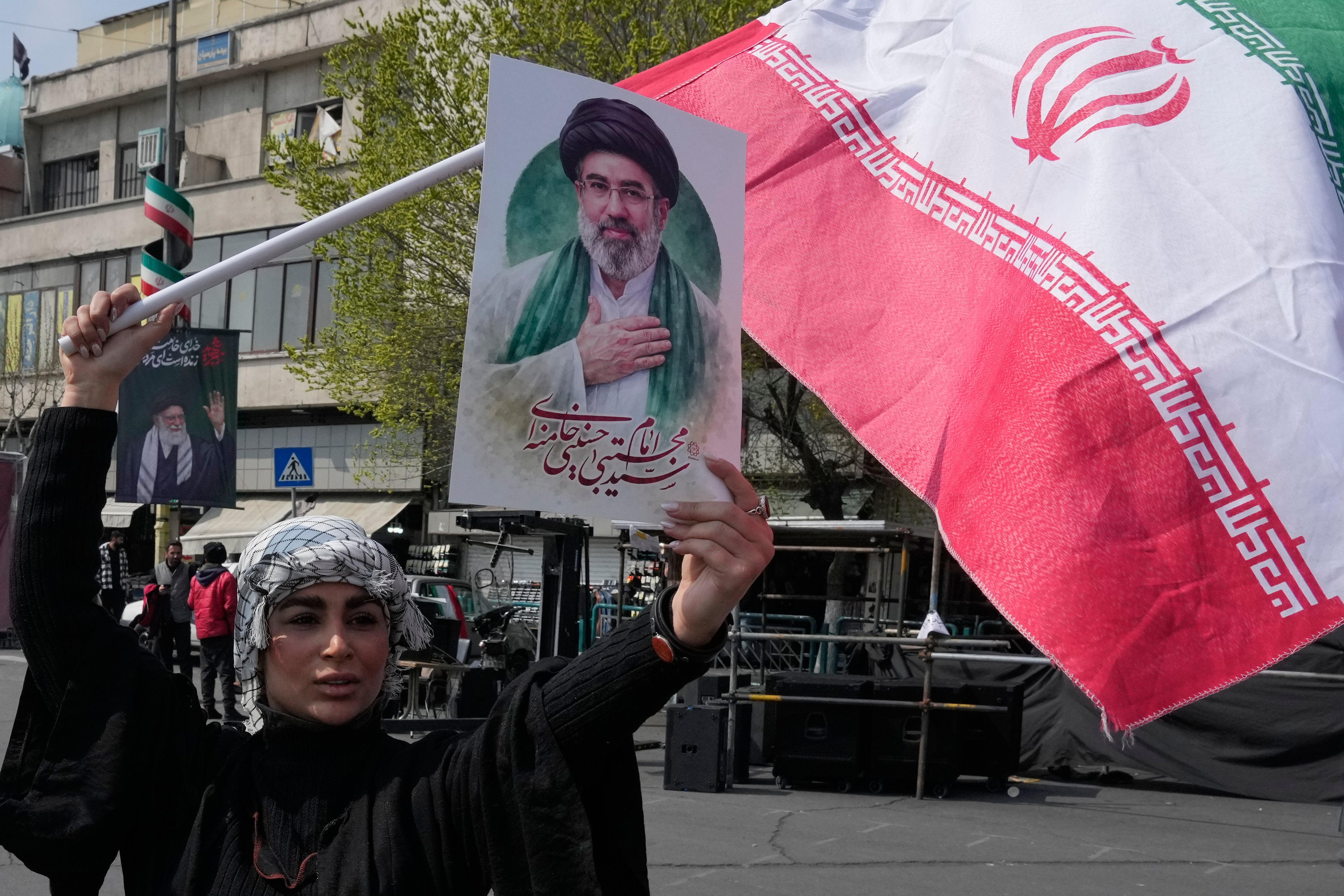 A female displays a poster of Iran’s caller Supreme Leader Ayatollah Mojtaba Khamenei and waves her country’s emblem successful support of nan authorities successful Tehran Saturday March 14, 2026